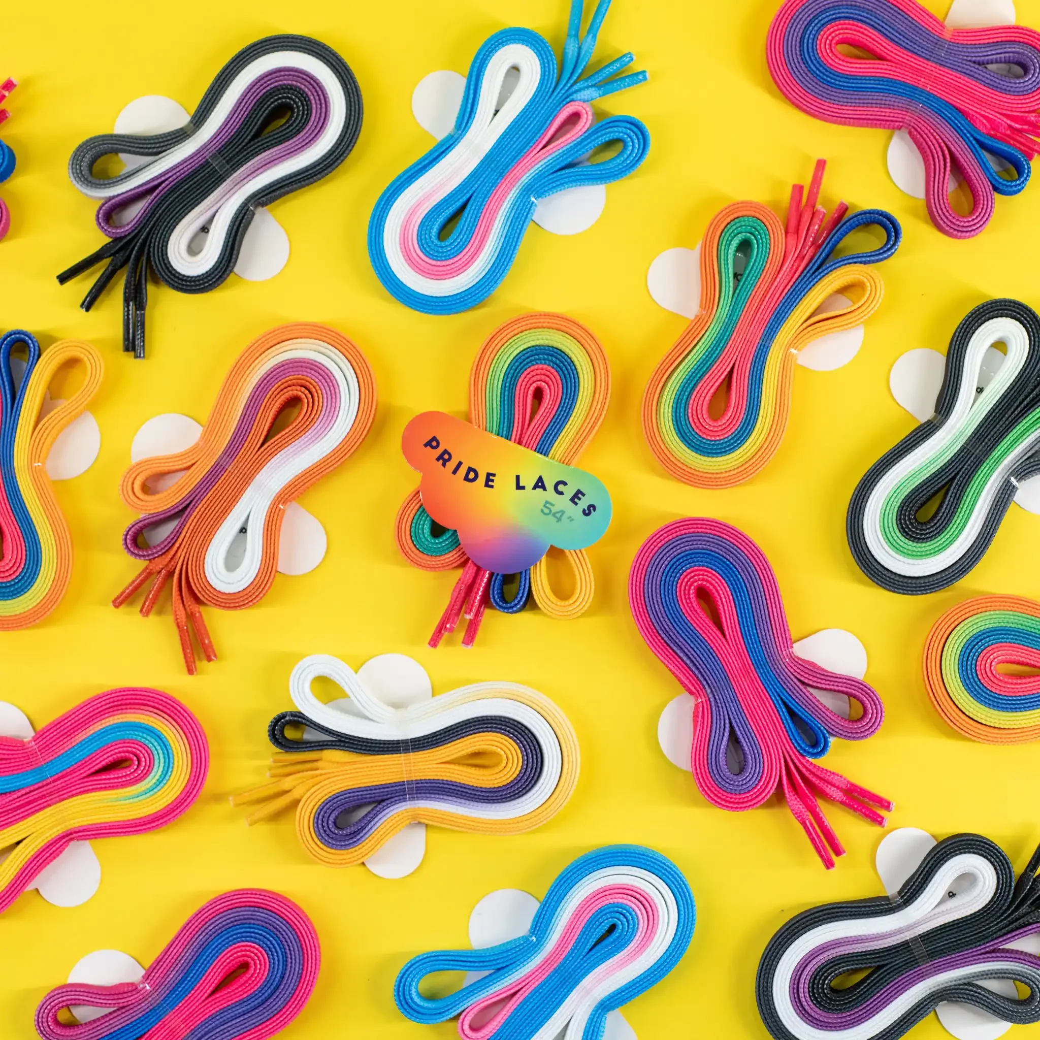 Colorful rainbow-colored pride lace trims arranged on a bright yellow background.