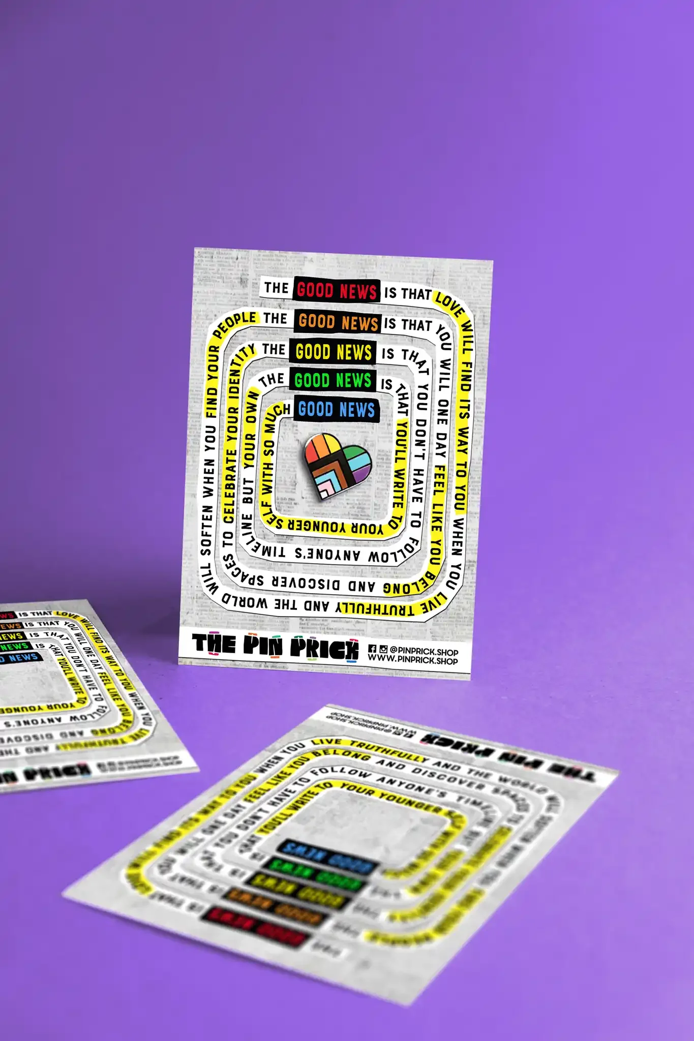 A flyer titled 'The Pin Prick' with colorful text and a small multi-colored heart graphic, placed on a purple background with additional flyers scattered around.