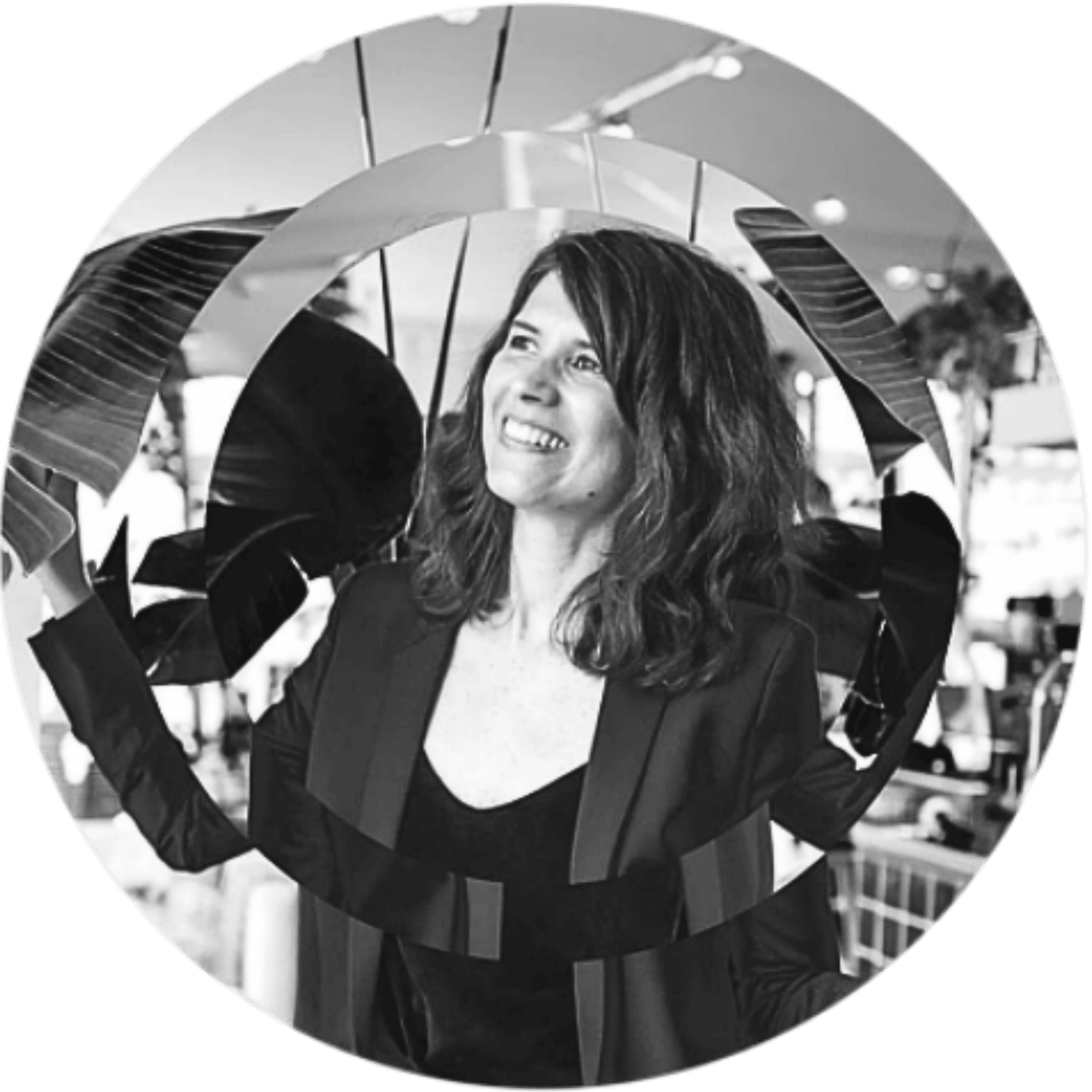 Nina Cambadélis, executive coach,  souriante regarde vers la droite, entourée de cercles. La photo est en noir et blanc.