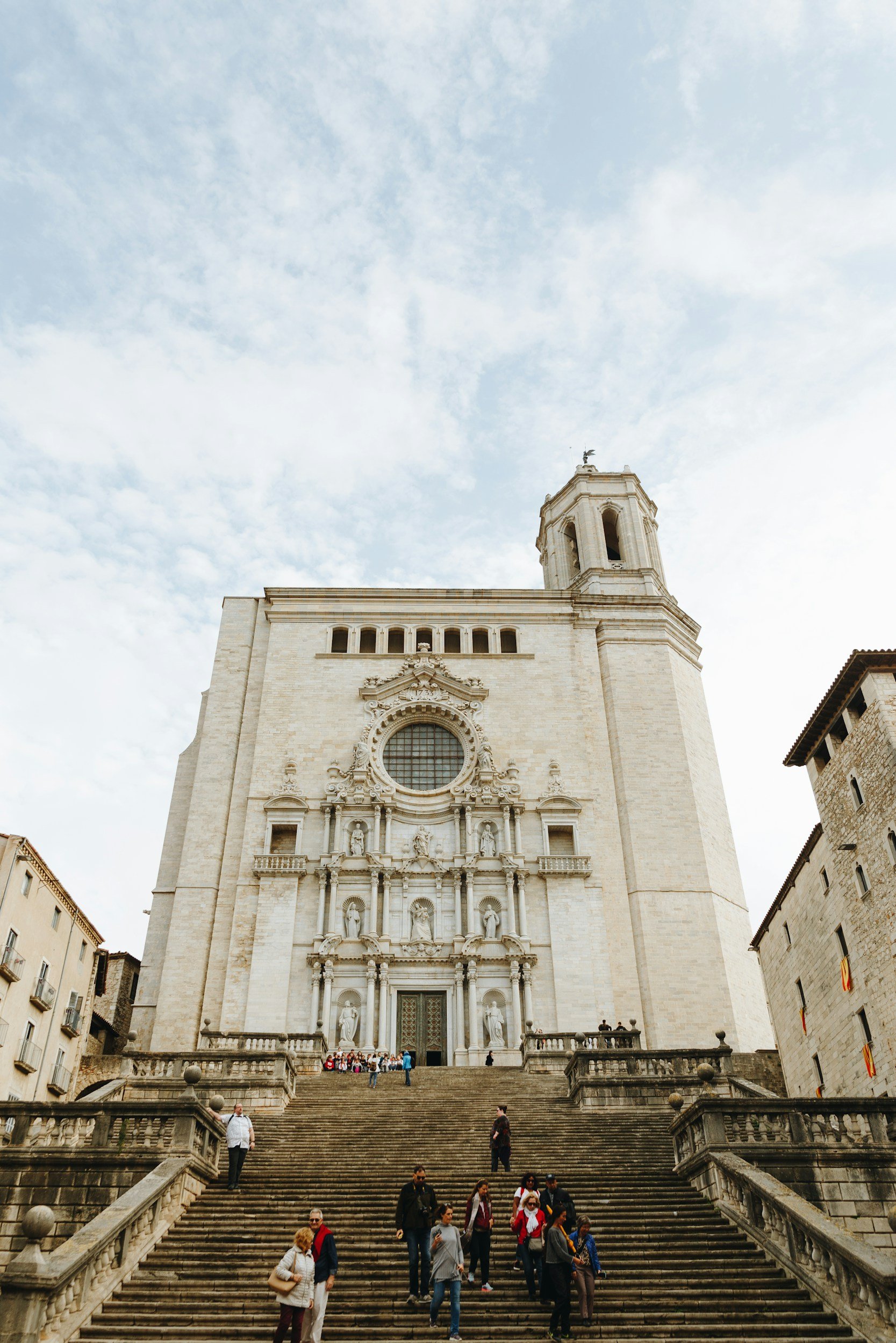 A historic church with grand stairs and ornate facade, with tourists and visitors walking up and down the stairs.