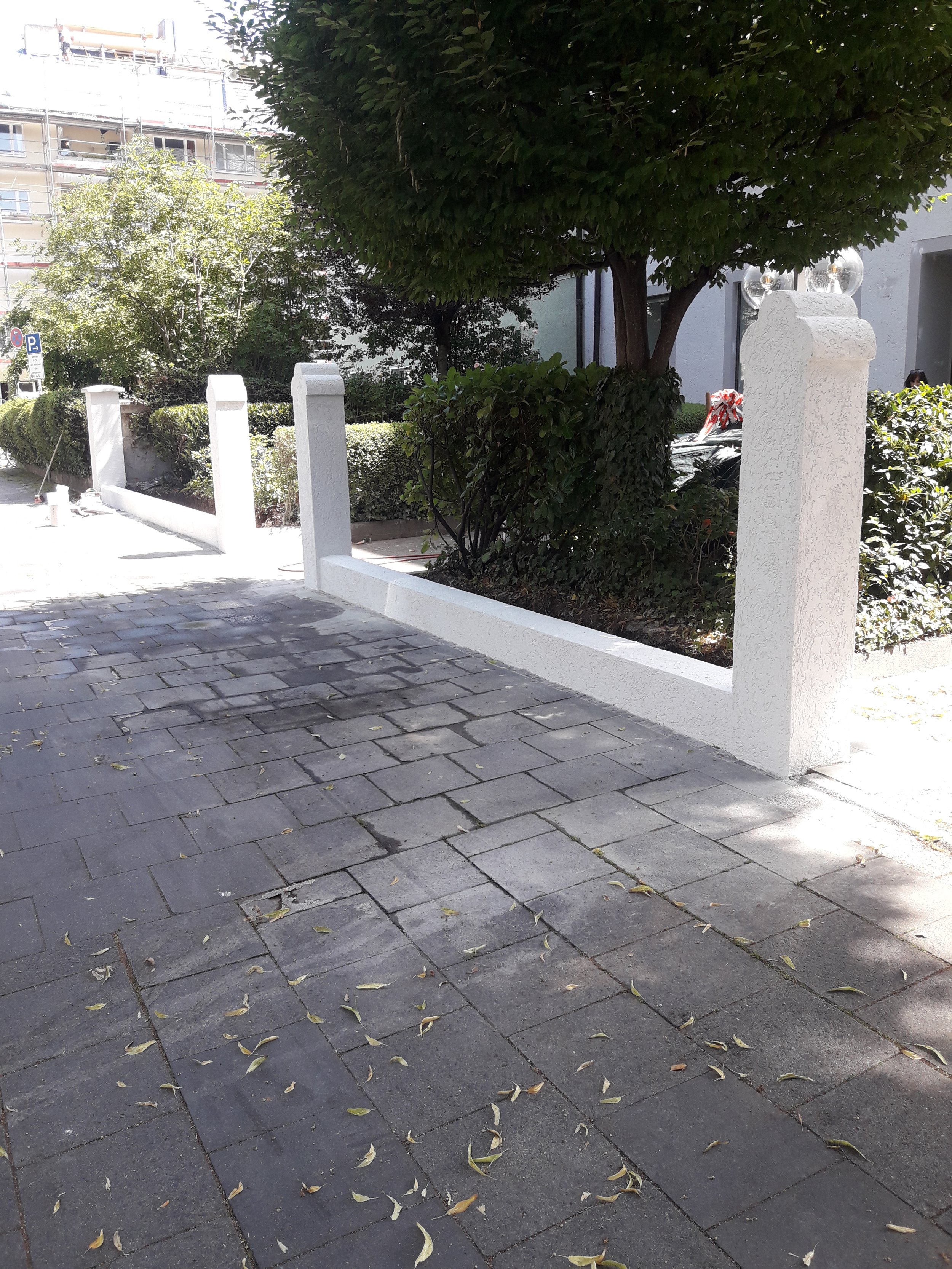 Sanierte Gartenmauer mit weißem Putz nach Fassadenarbeiten, Bauprojekt Arcisstraße München