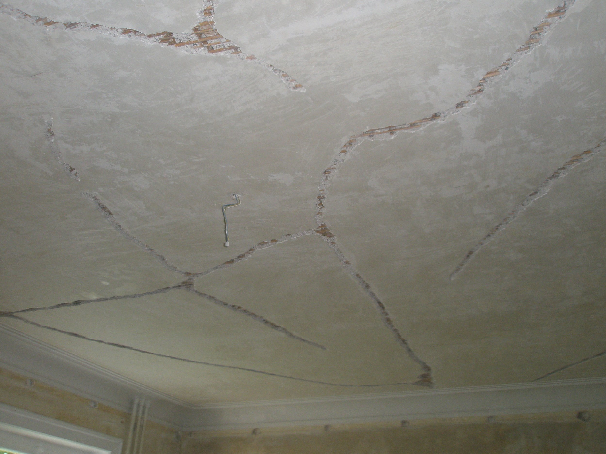 Decke mit sichtbaren rissen und Kabeln