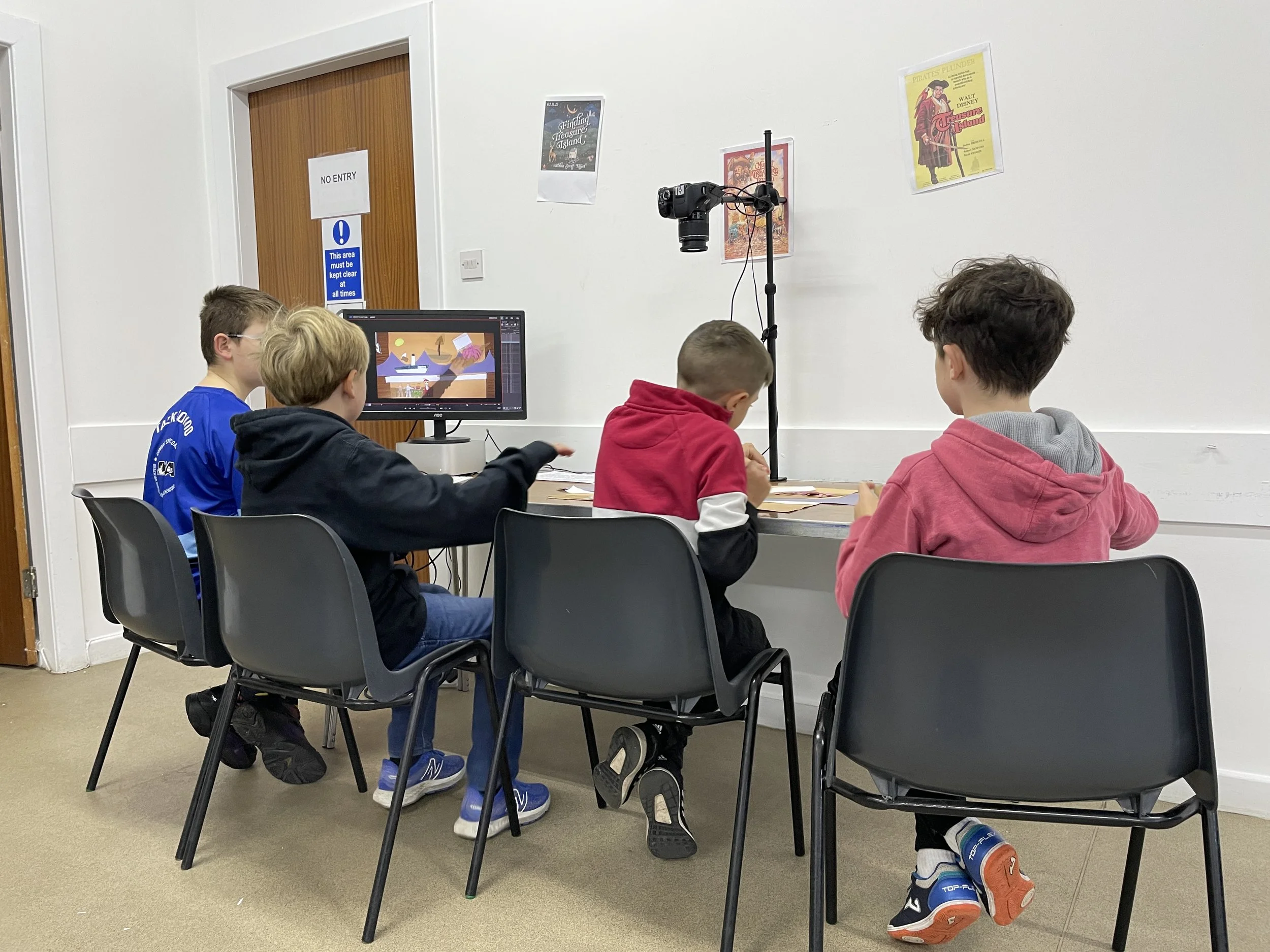 Four children sit and 2D animate at a desk