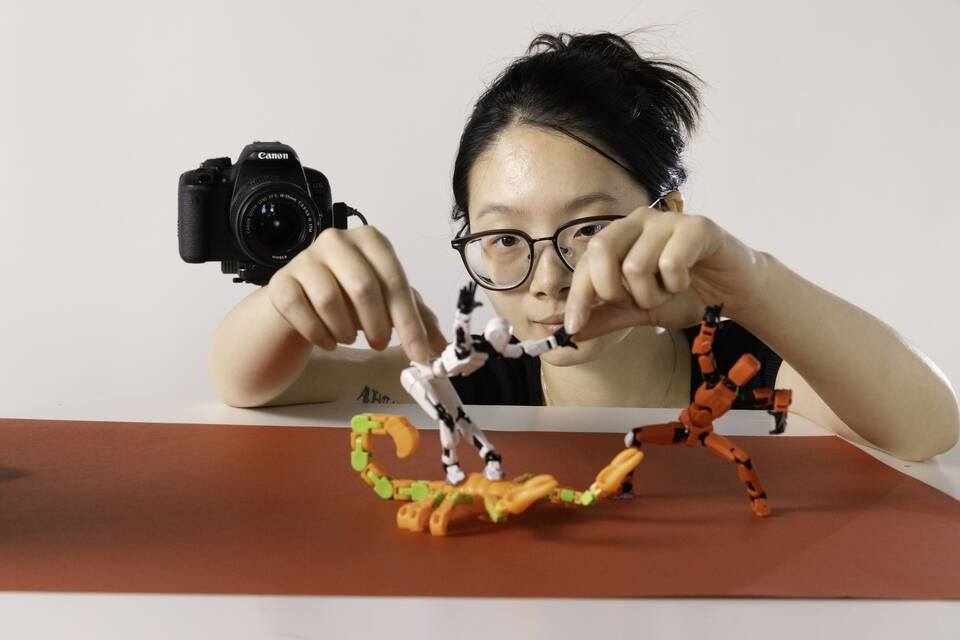 two figurines, one on top a scorpion, are being animated by a woman
