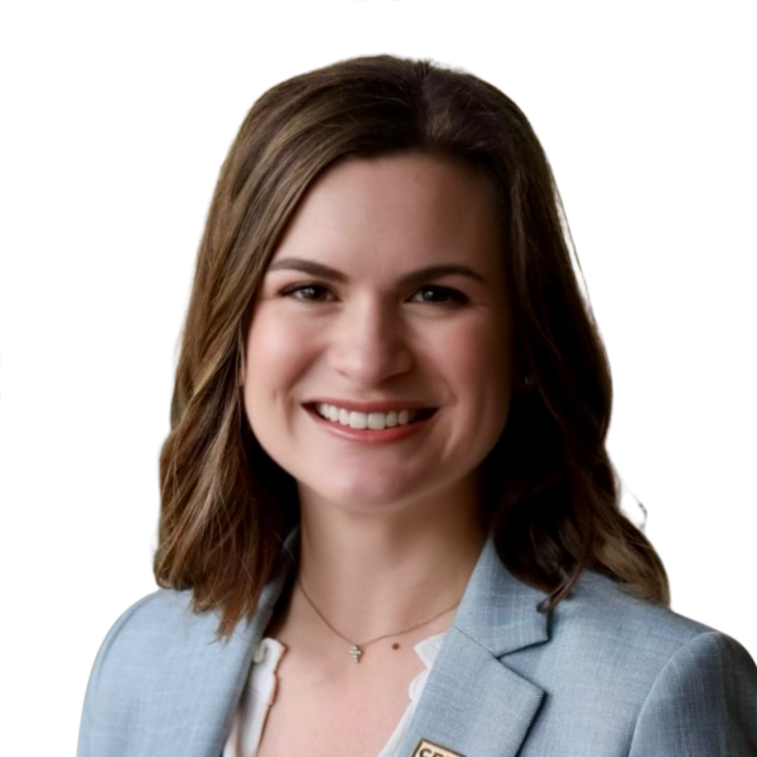 Portrait of a smiling woman with shoulder-length brown hair, wearing a light blue blazer and a white top, against a white background.