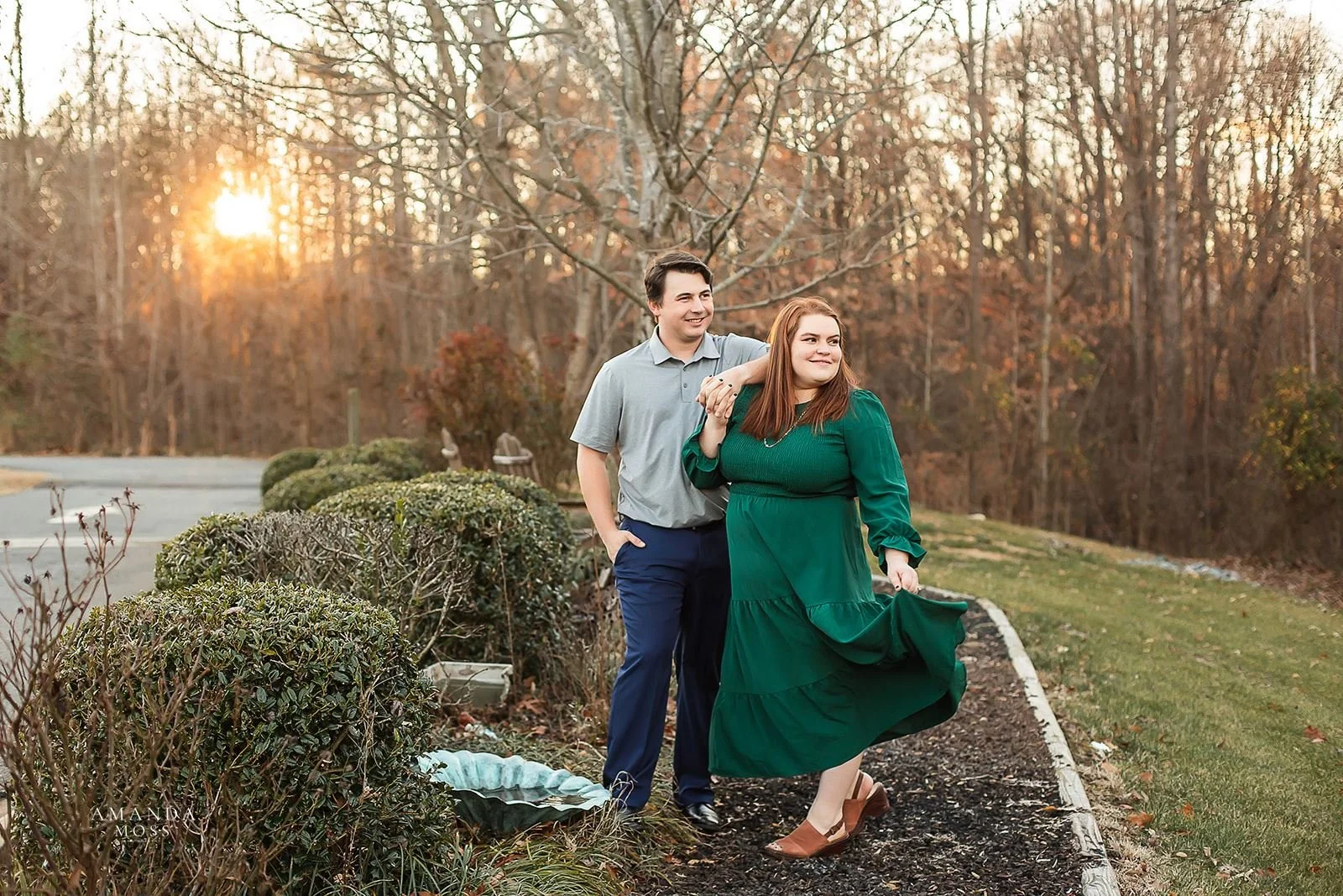 couple looks off into distance during fall sunset at outdoor engagement session in huntersville nc