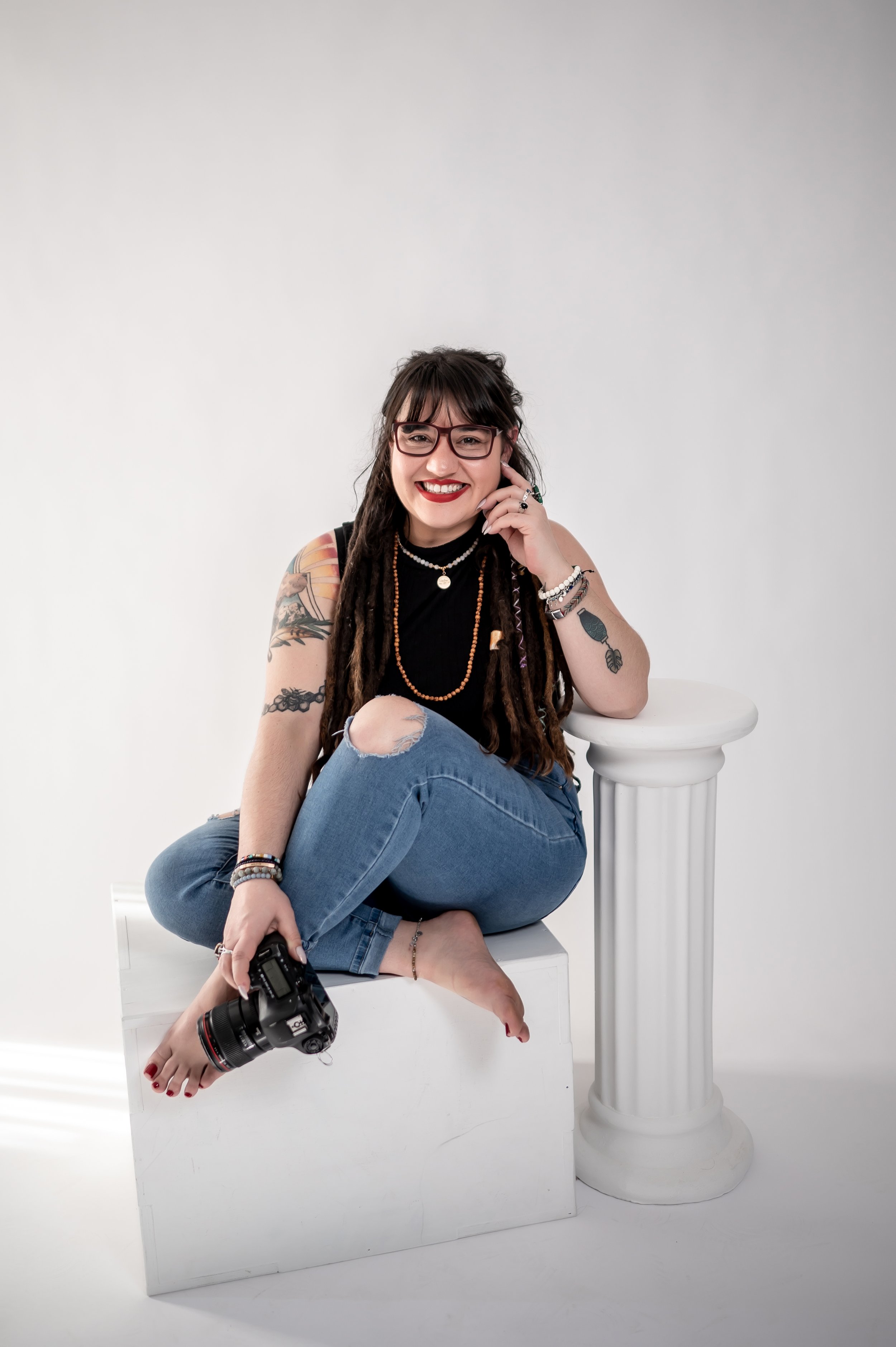 charlotte wedding photographer poses with camera for headshot dreadlocks tattoos red lipstick