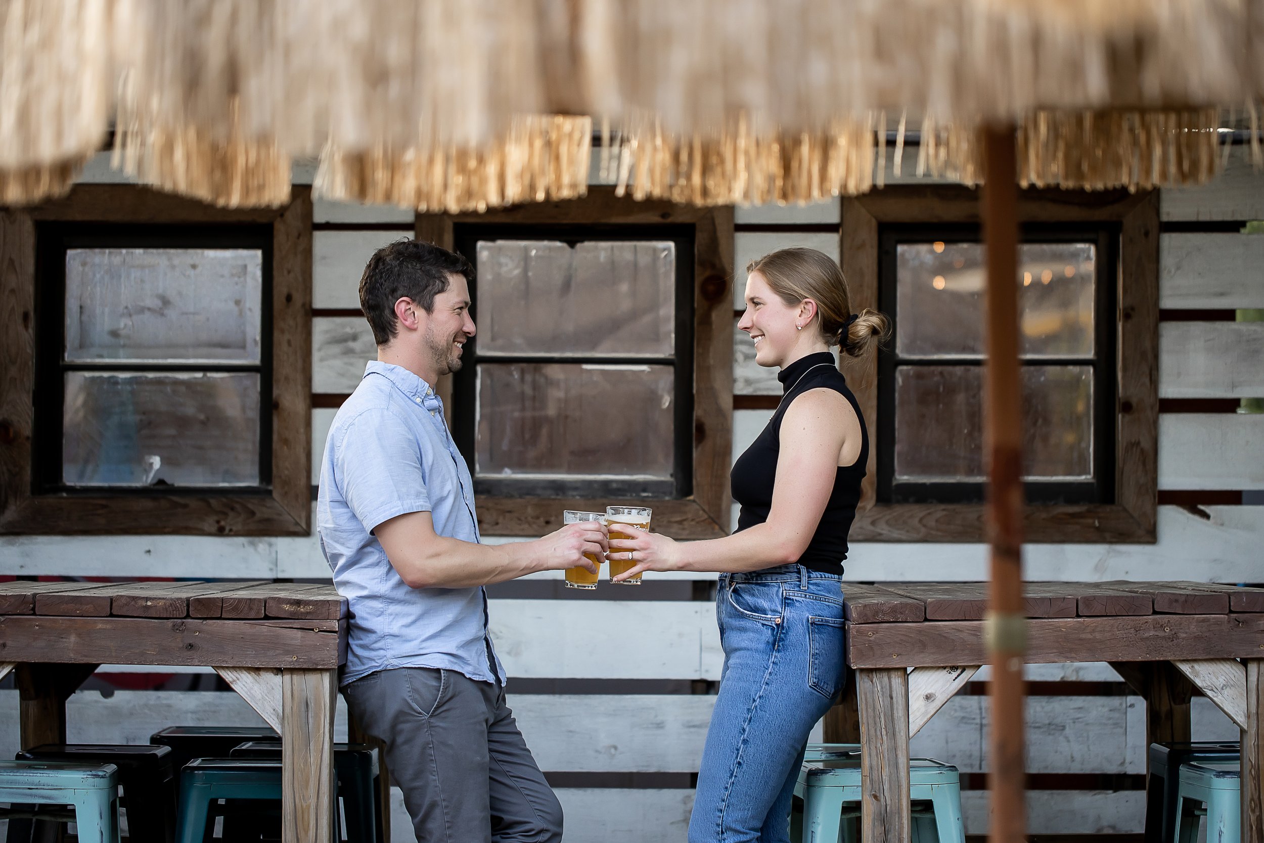 couple shares beer in noda neighborhood charlotte nc engagement session photographer