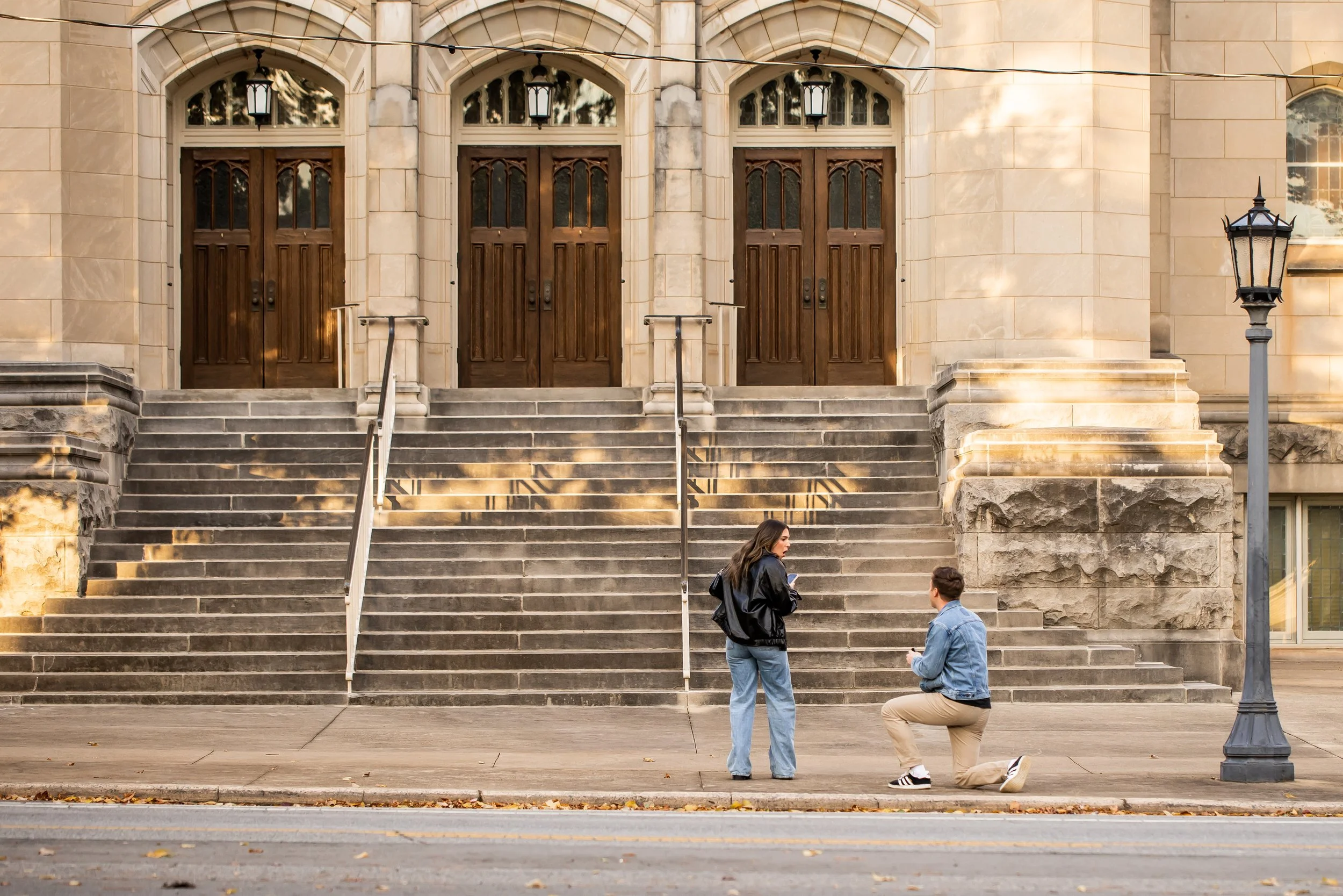 woman is surprised by boyfriends proposal in front of church during evening walk charlotte nc