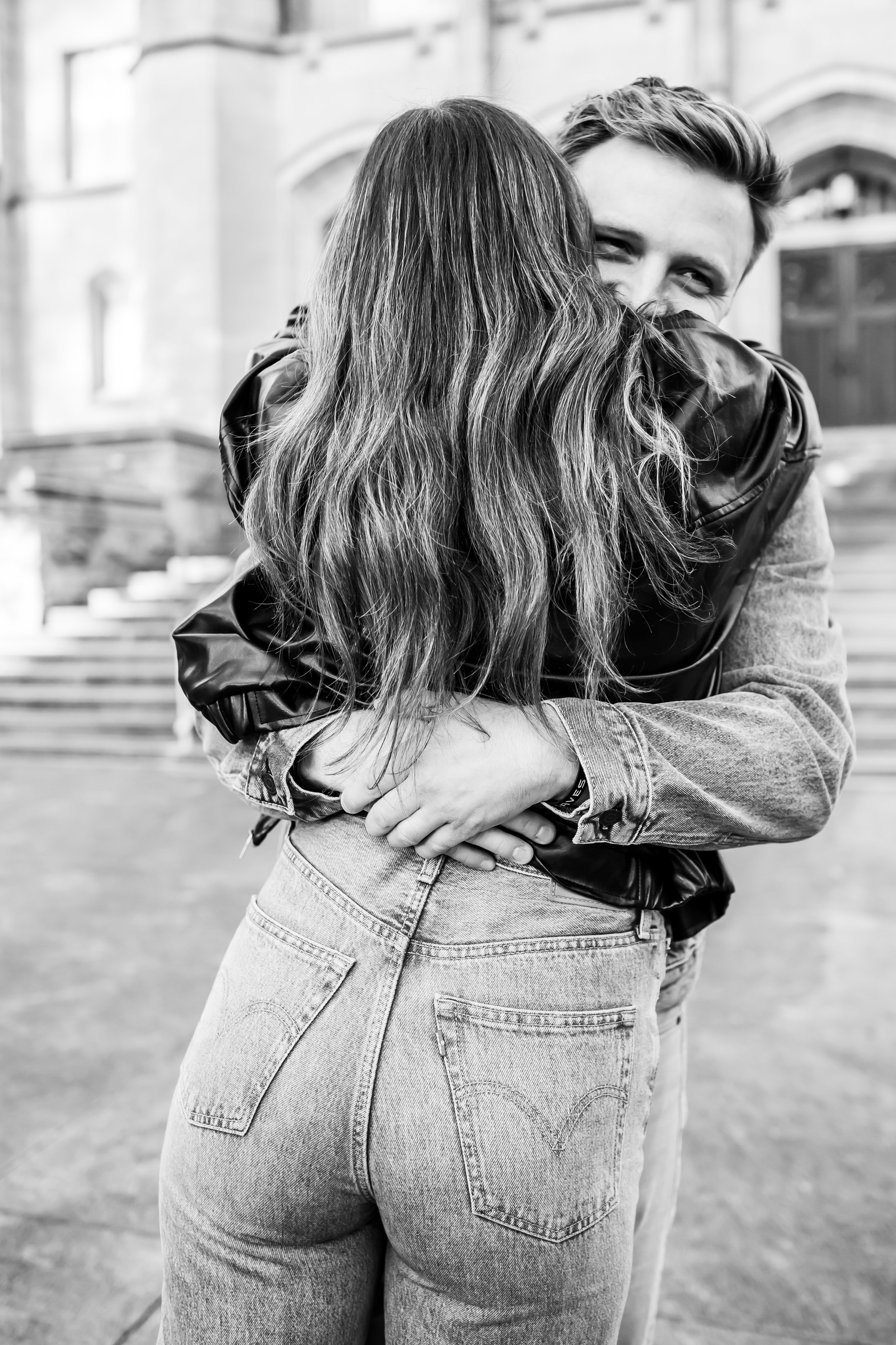black and white photo of a big hug between a newly engaged couple secret proposal