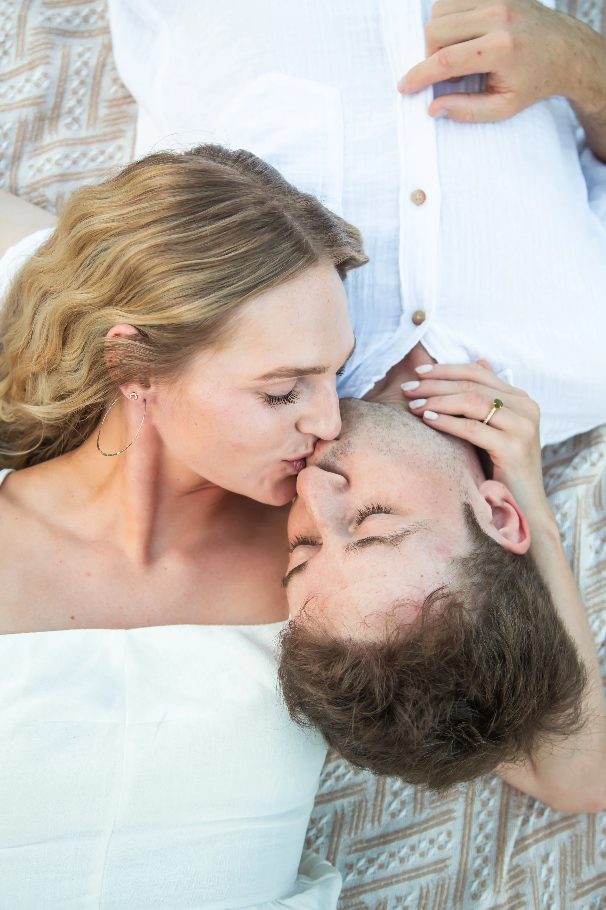 white outfits soft fabric what to wear for your engagement session couple kissing on blanket