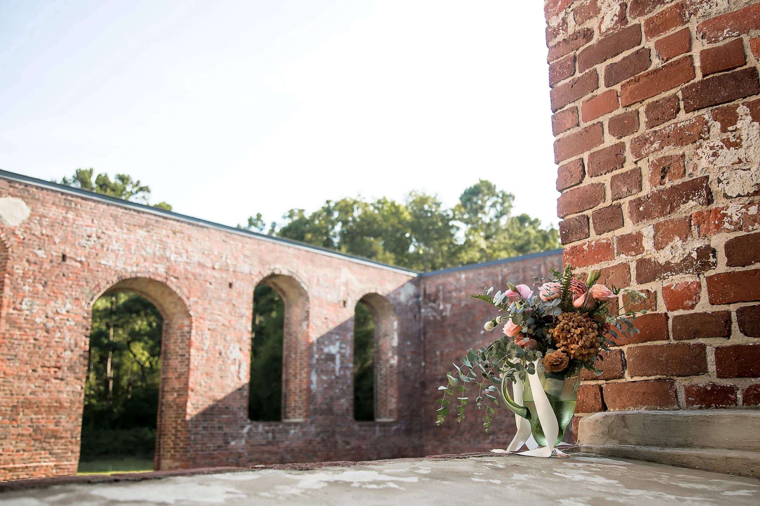 wedding bouquet rests against wall in church ruins with no ceiling wilmington nc