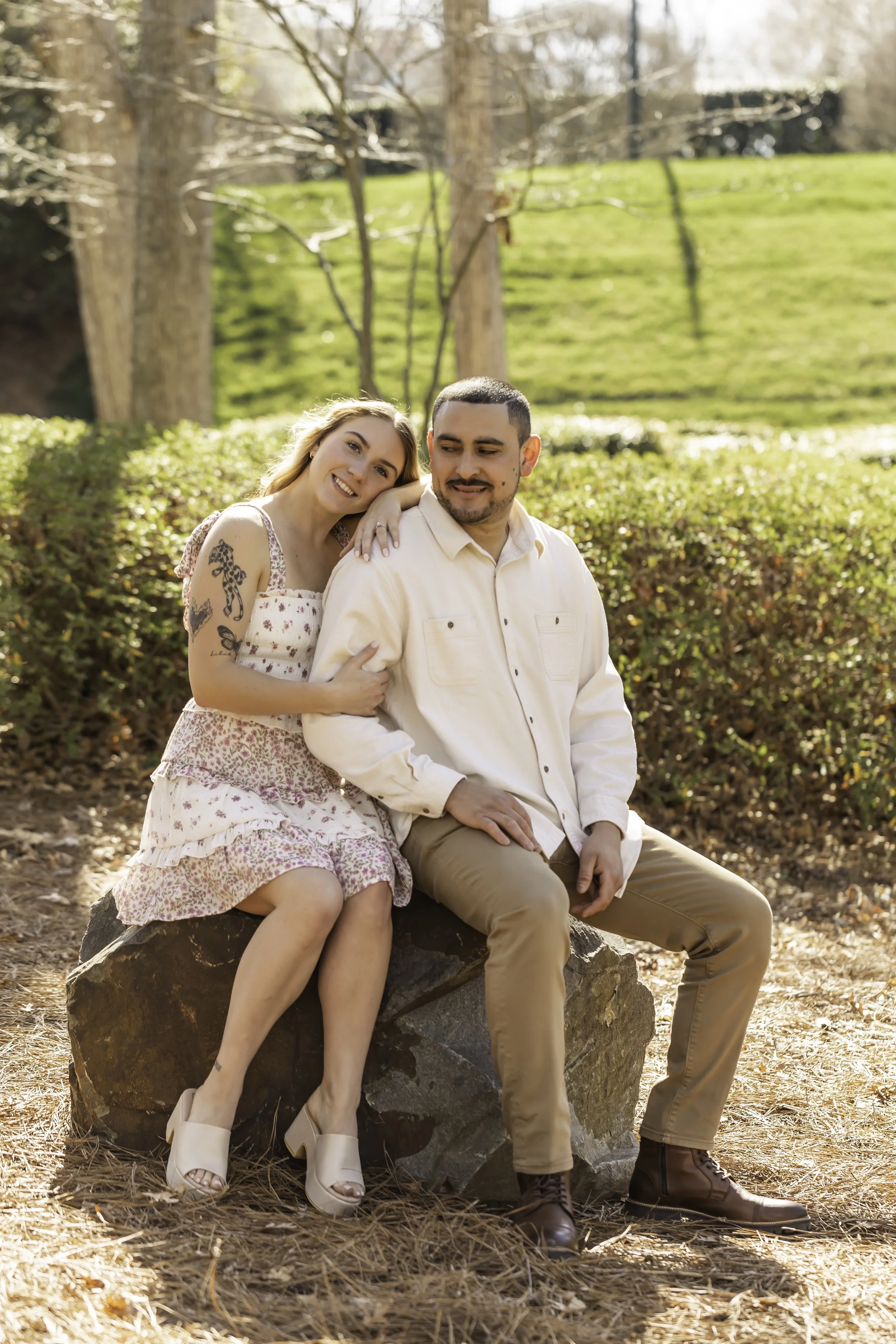 Engagement portraits of Erick and Faith near the lake at Cullman Park, with lush greenery in the background