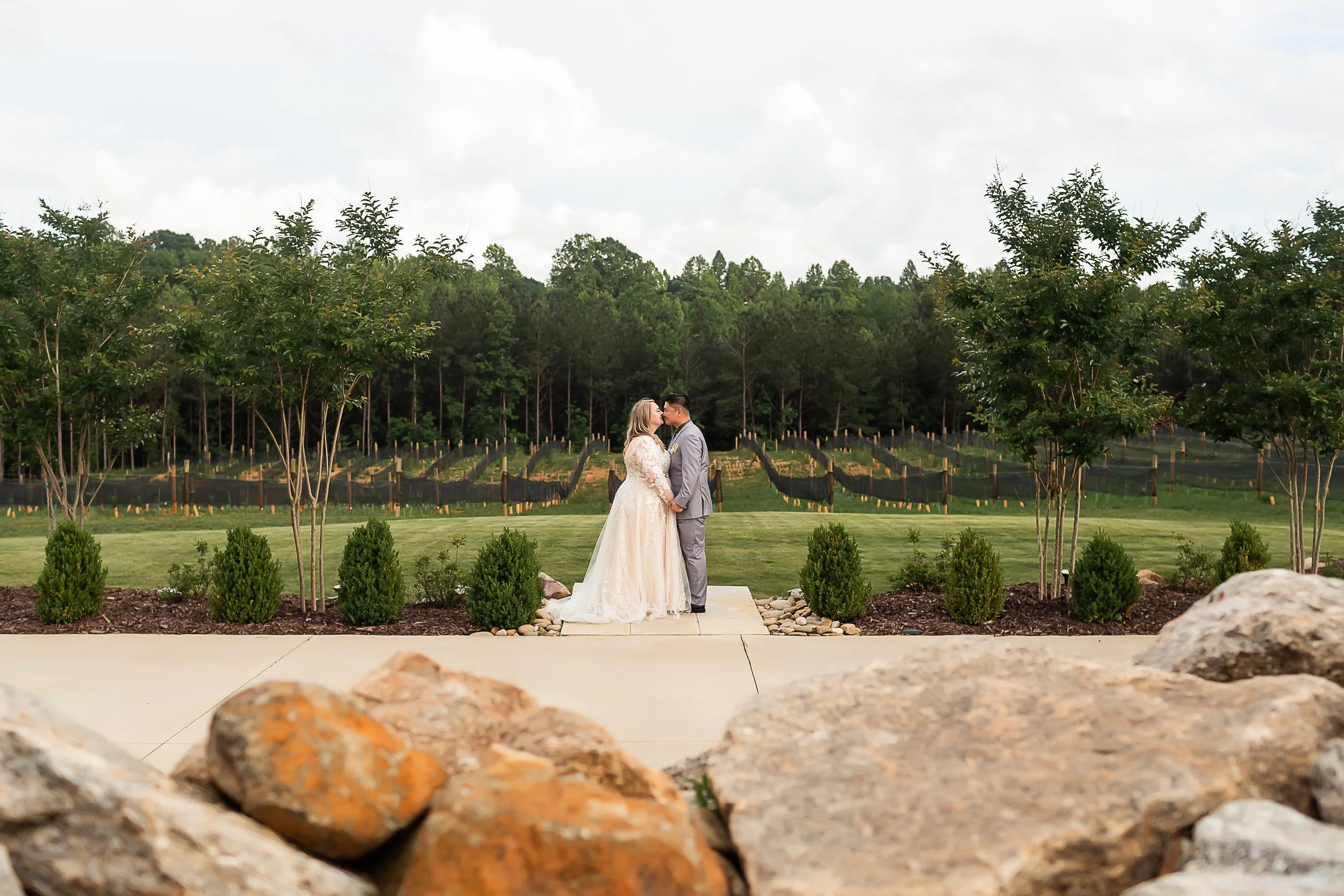 Overcast sky vineyard wedding couple embracing north carolina