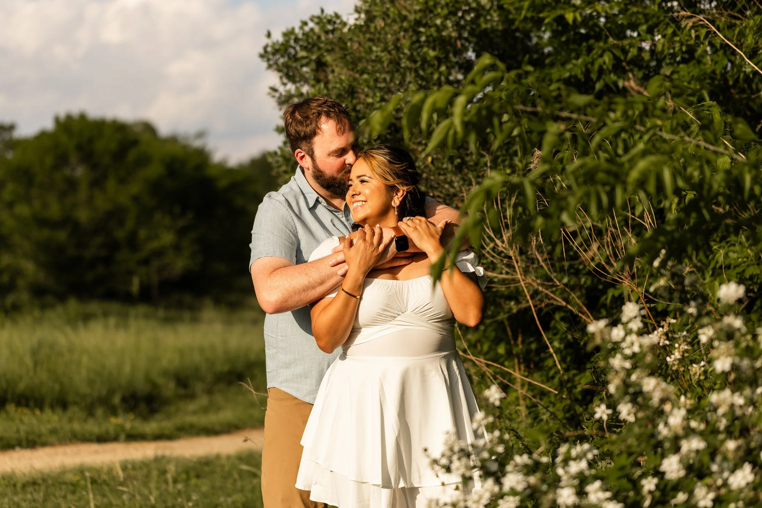 Golden hour engagement photo at Clark's Creek Nature Preserve with soft sunlight highlighting the couple's natural chemistry