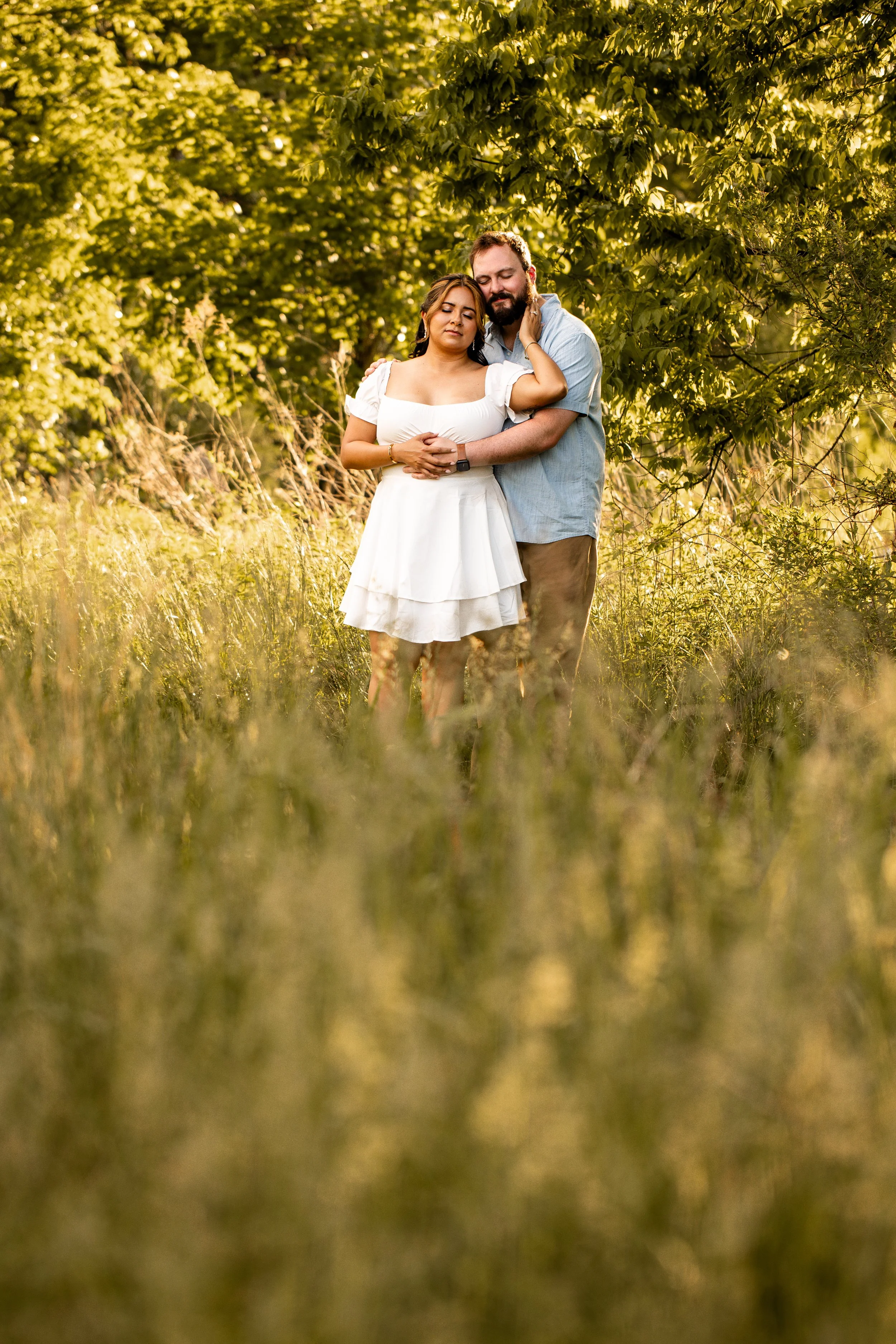 Golden hour engagement photo at Clark's Creek Nature Preserve with soft sunlight highlighting the couple's natural chemistry