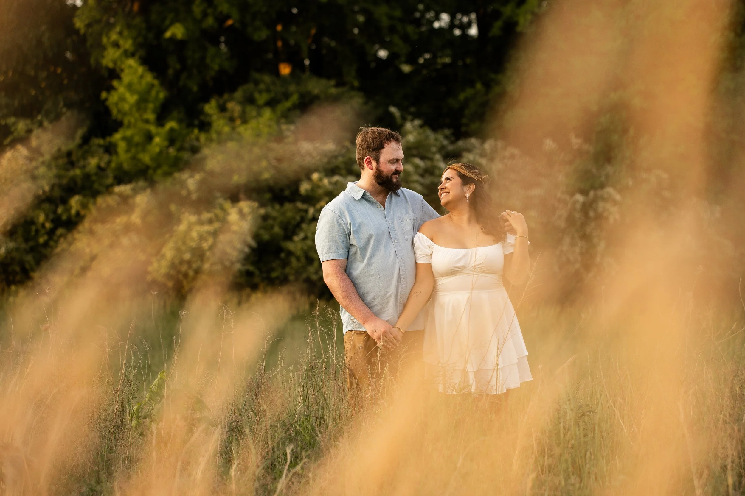 Golden hour engagement photo at Clark's Creek Nature Preserve with soft sunlight highlighting the couple's natural chemistry