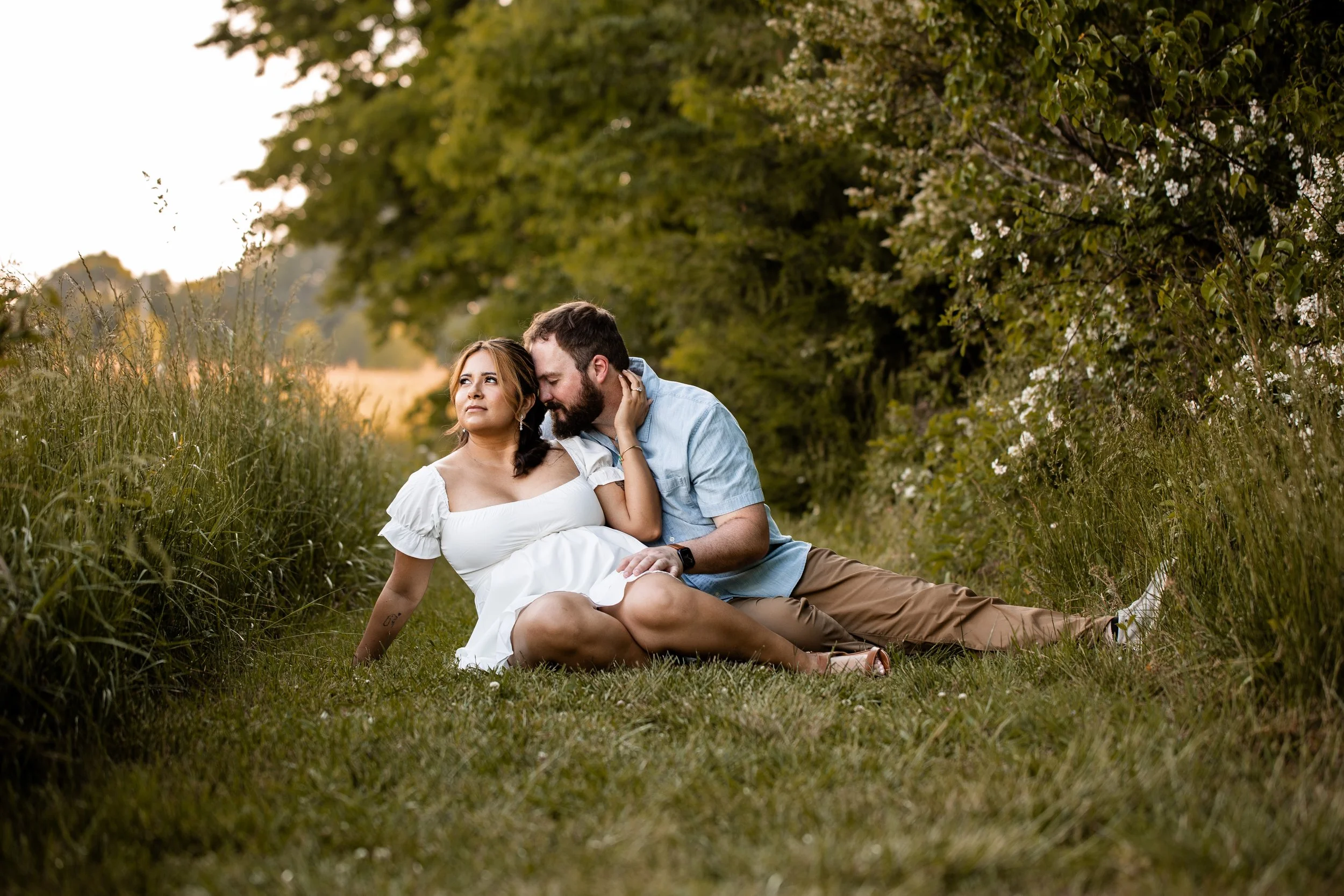 Vanessa and Alex sharing a quiet moment among white wildflowers at Clark's Creek Nature Preserve during their engagement session