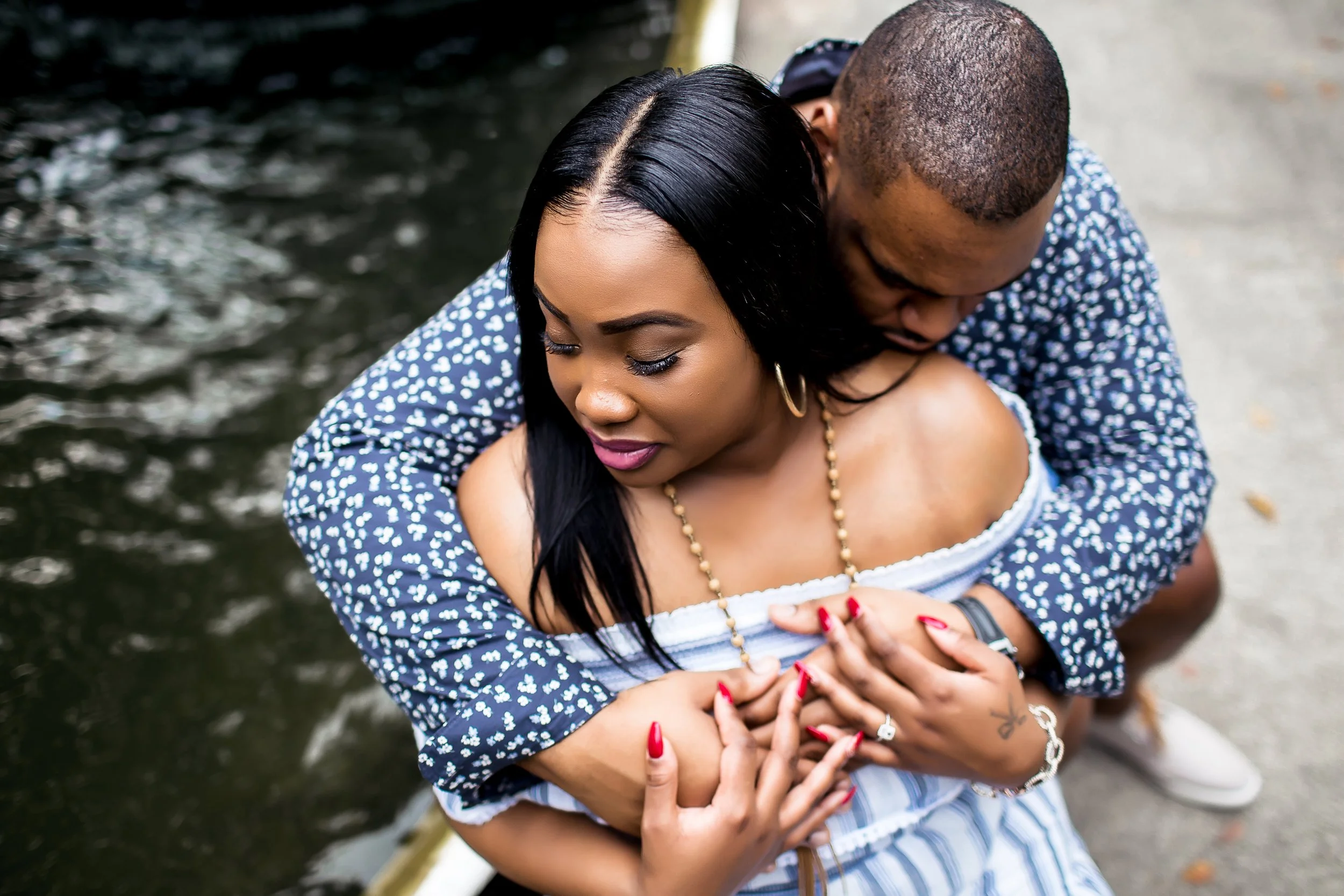 beautiful black couple embraces in engagement session by the water charlotte nc