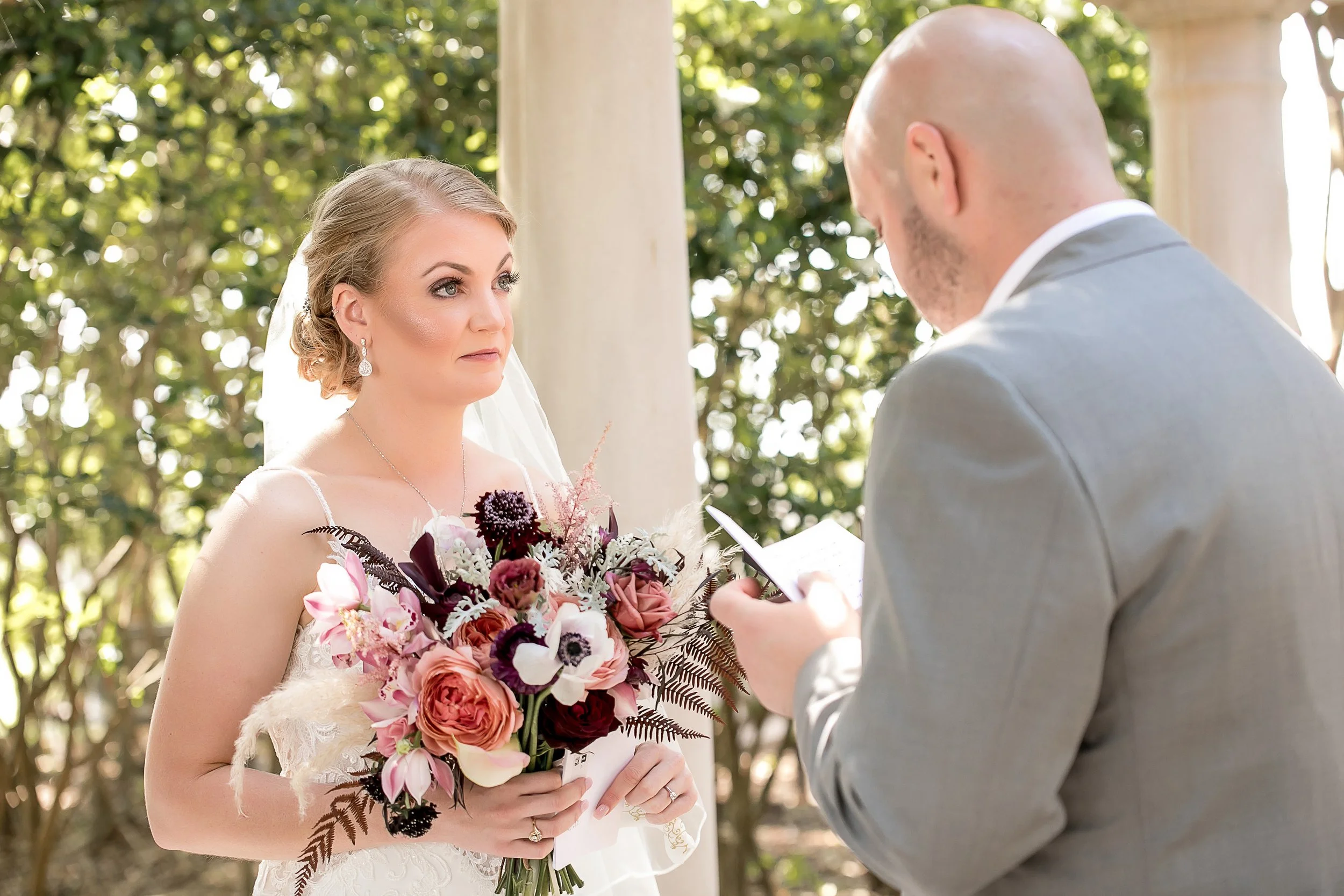 close up of bride looking at groom while he reads vows