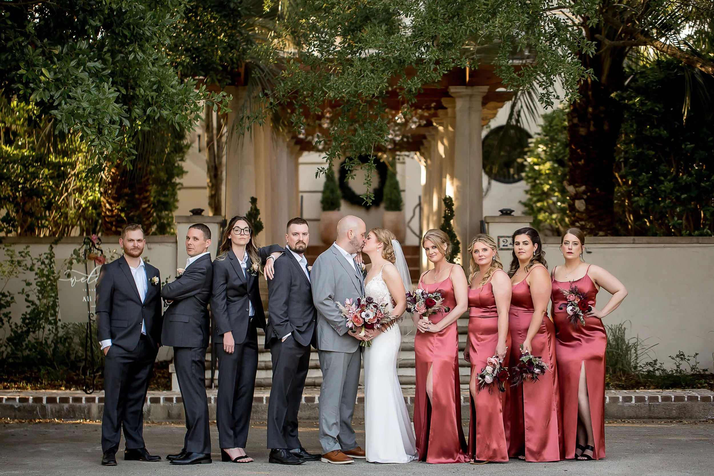 elegant wedding party poses in front of charleston mansion