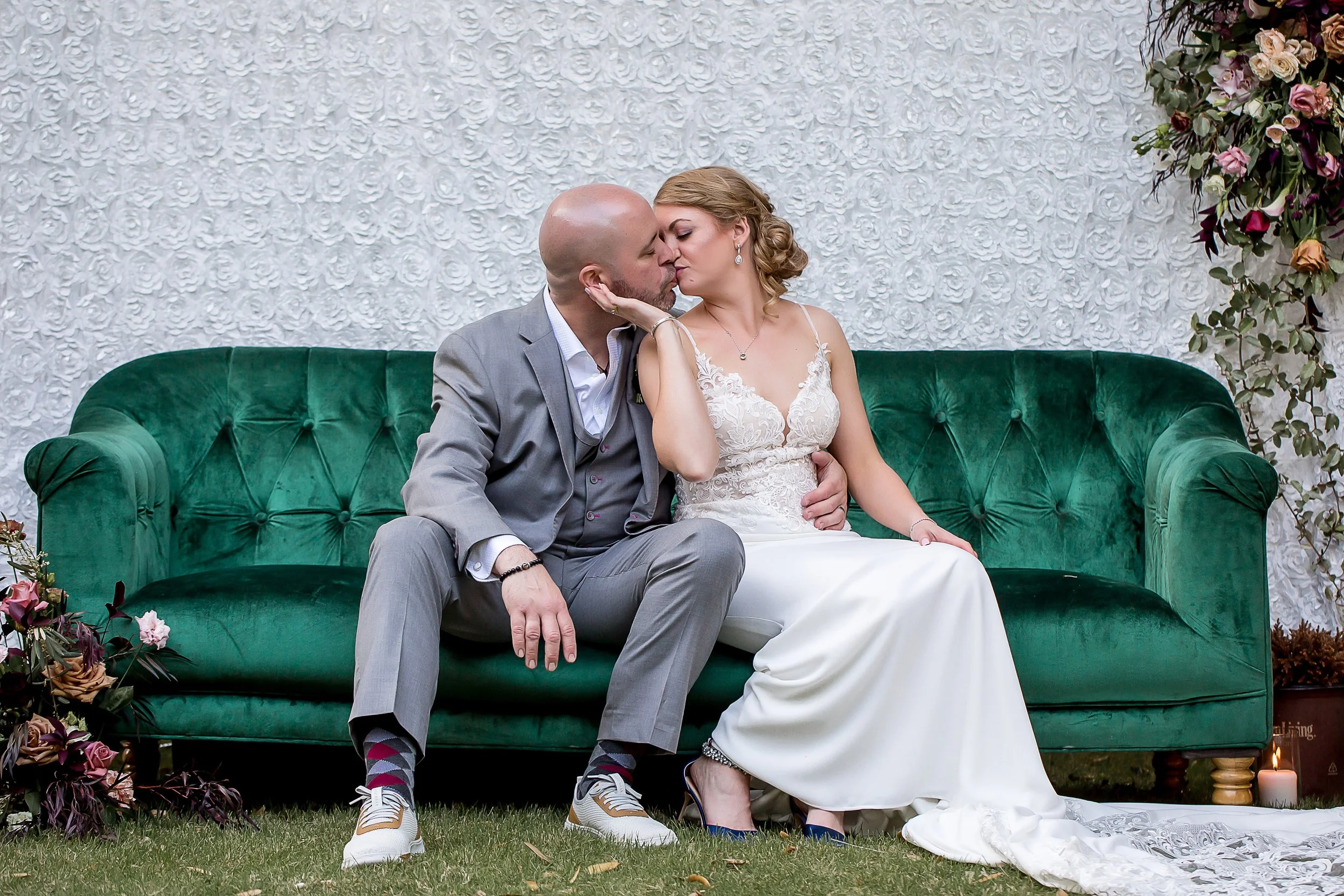 bride and groom destination wedding kiss on green velvet couch