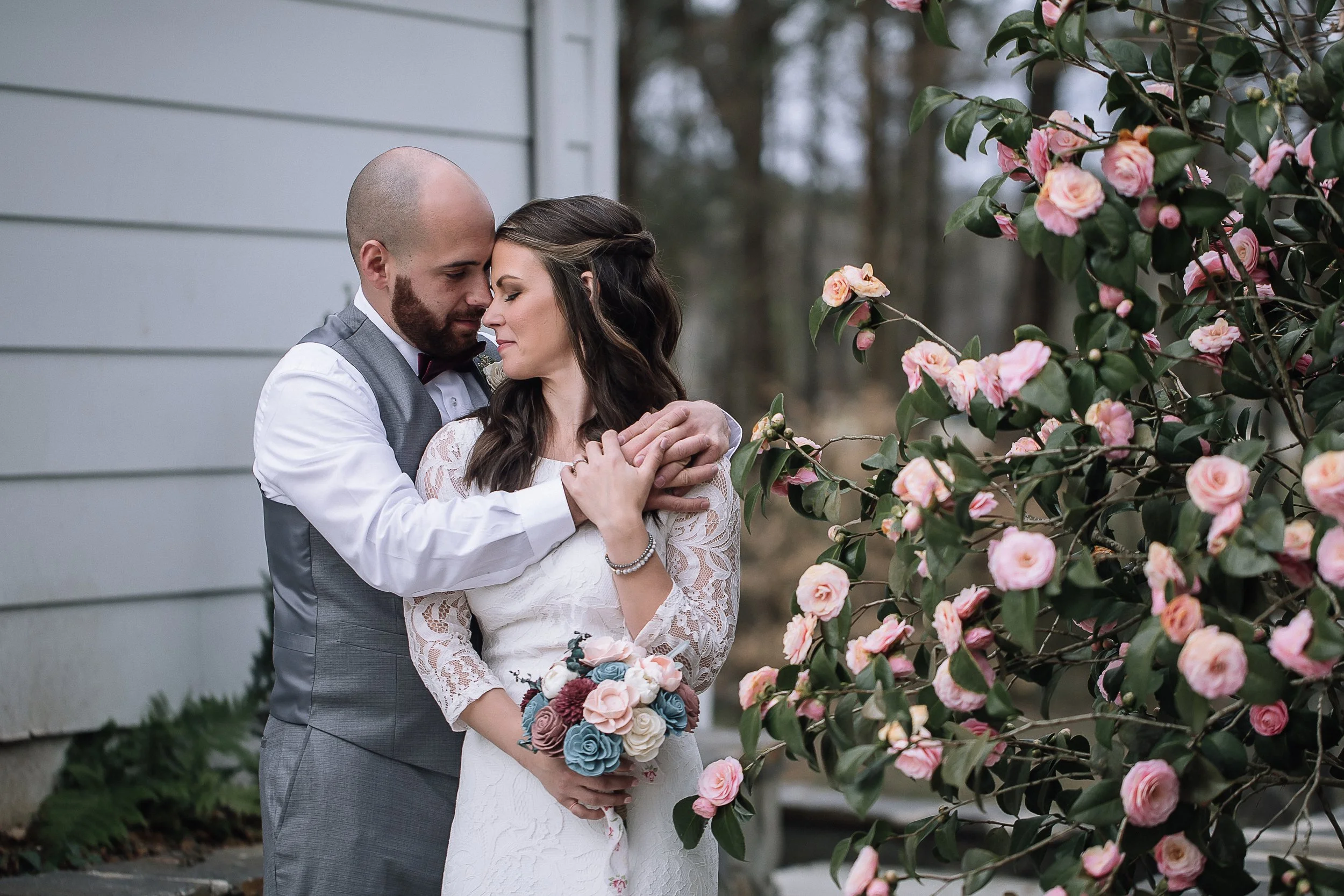 intimate micro wedding south carolina couple embraces in front of pink flowers