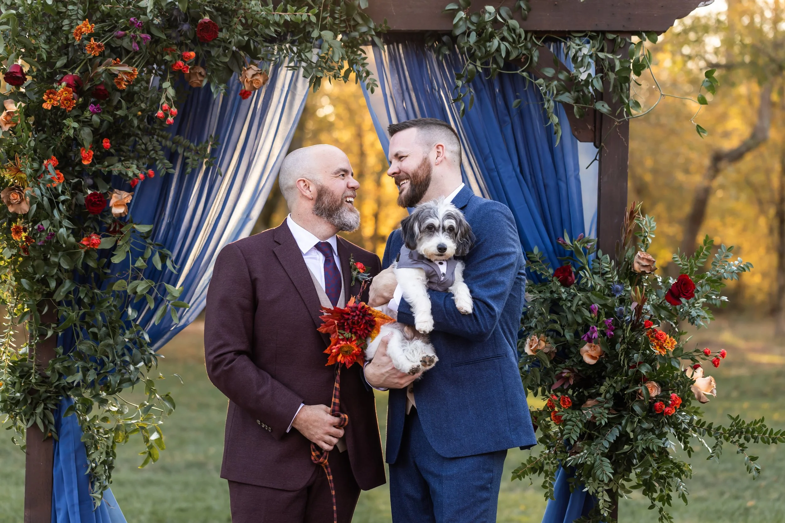 gay wedding lgbt couple with their dog in front of a floral arbor fall wedding charlotte nc