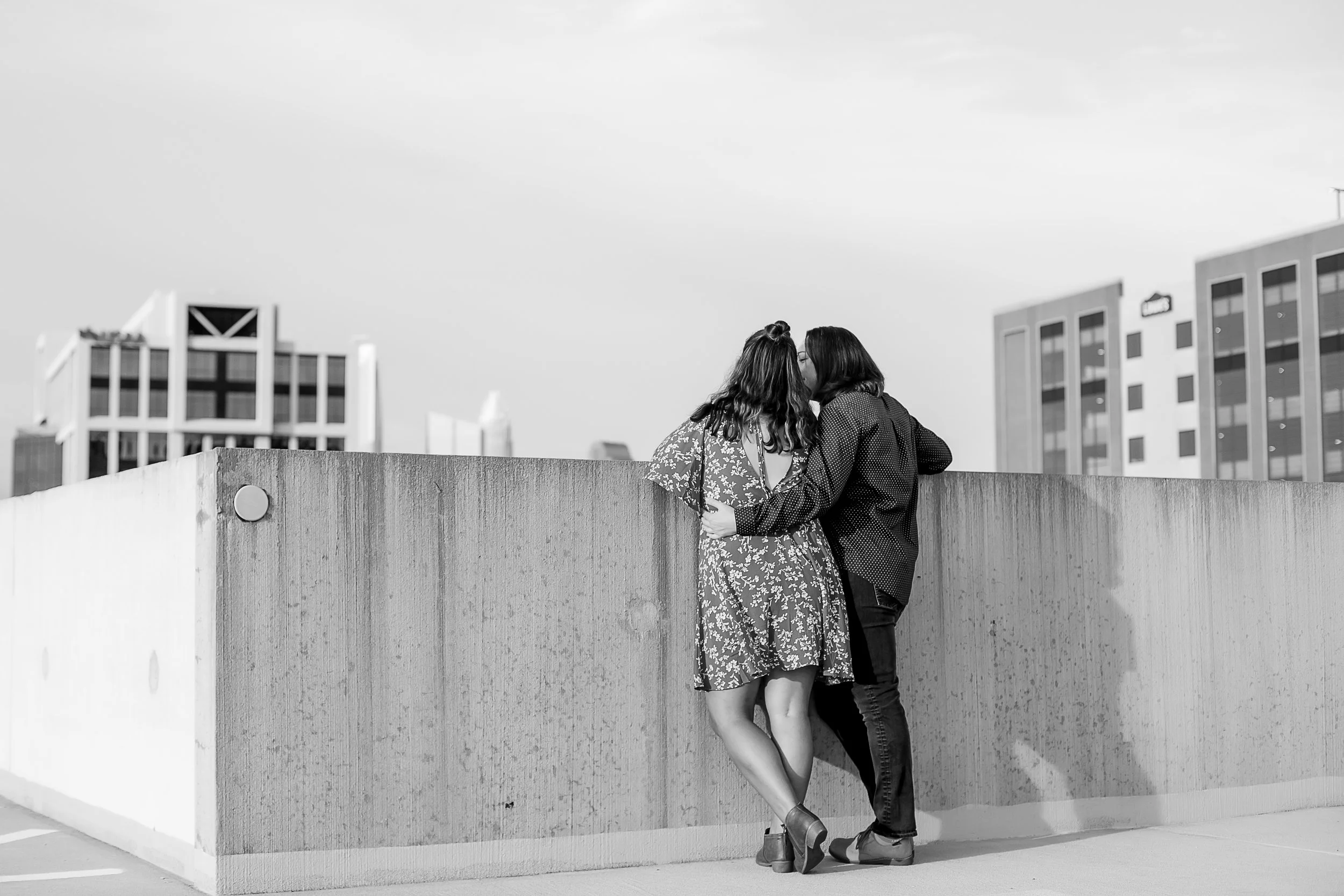 black and white image of lesbian lgbt couple on southend charlotte nc rooftop parking deck overlooking the city