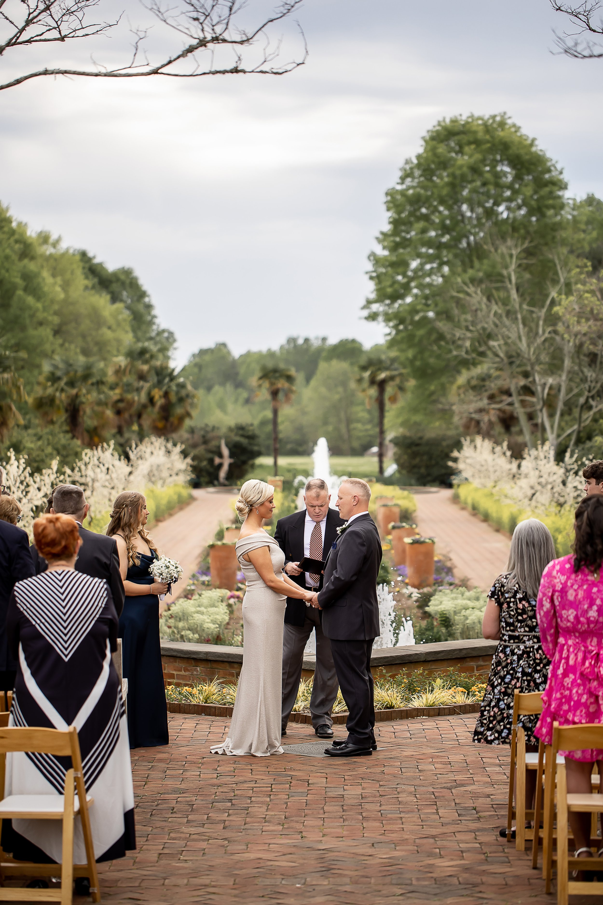 photo of bride and groom exchanging vows at daniel stowe botanical garden belmont nc