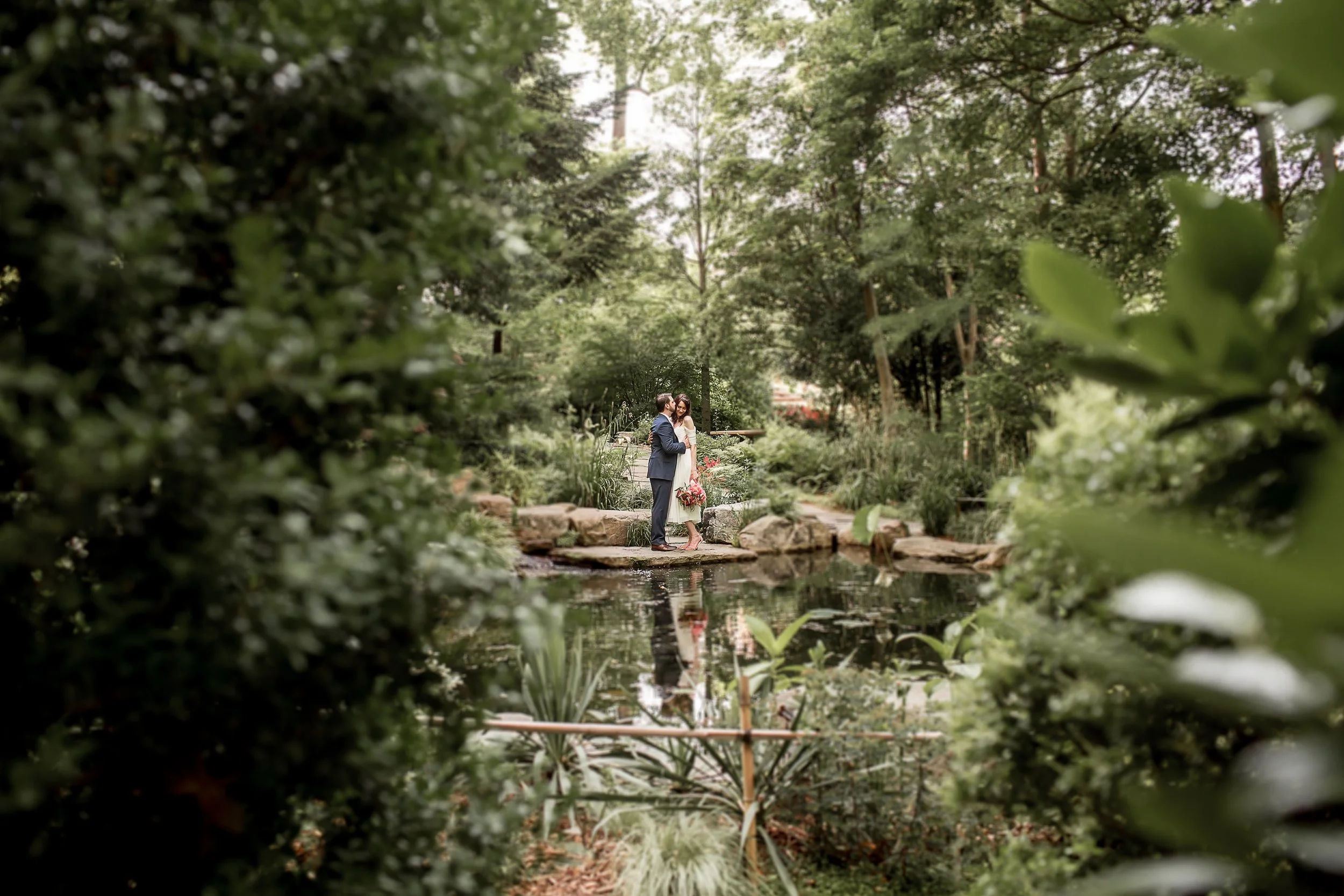 uncc botanical gardens private elopement bride and groom reflection in water