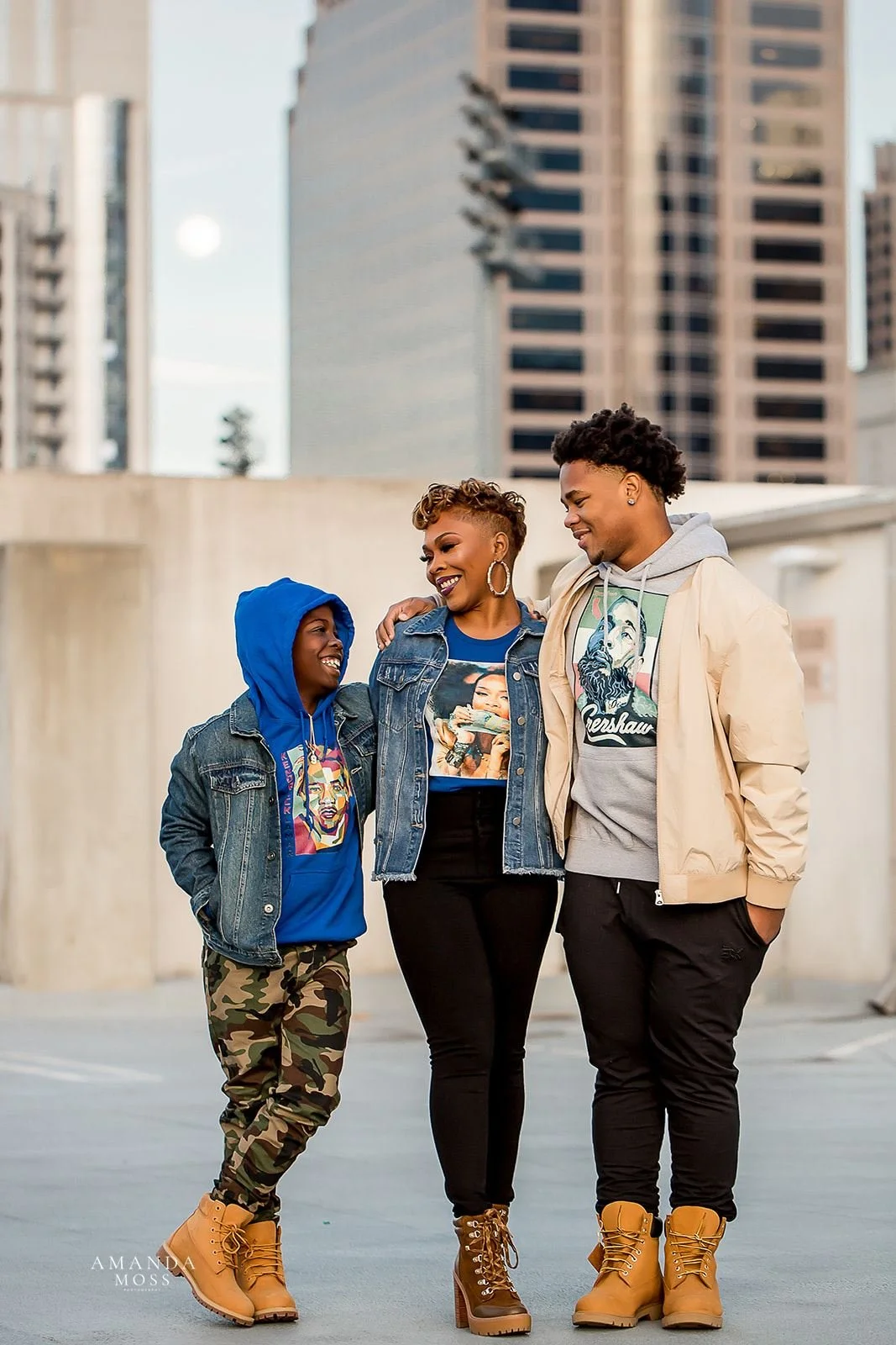 mother and sons wear hoodies and boots in an outdoor family photoshoot on a parking deck in downtown charlotte, nc