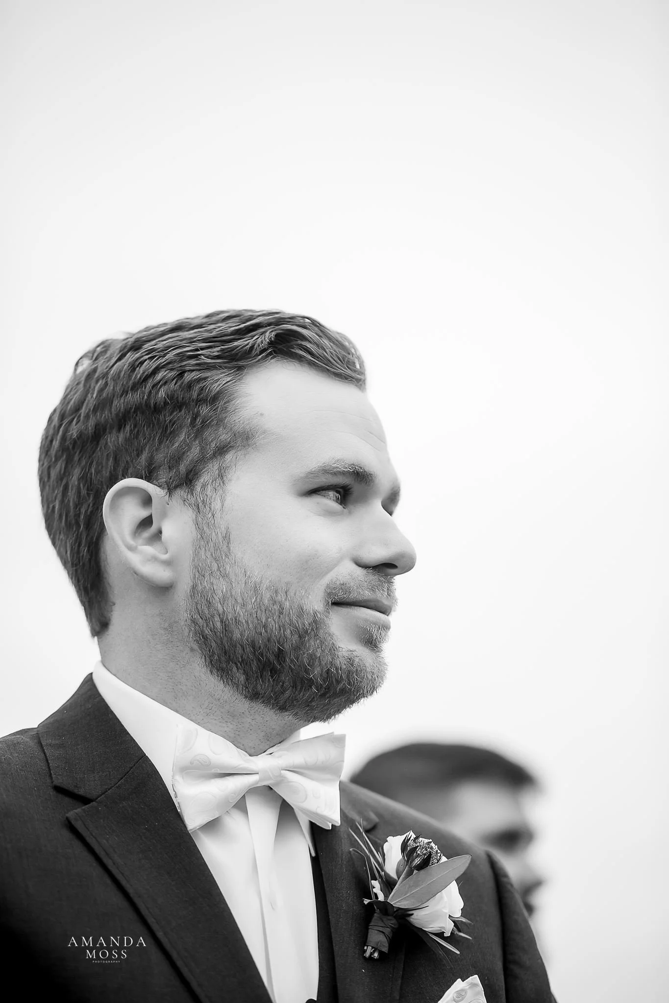 close up black and white photo of grooms face as he sees his bride for the first time