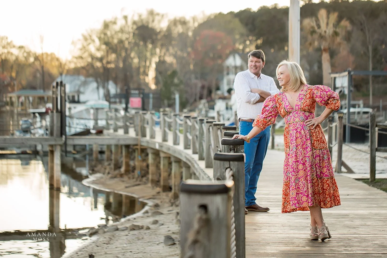 mature couple poses and looks off into distance during sunset at lake norman