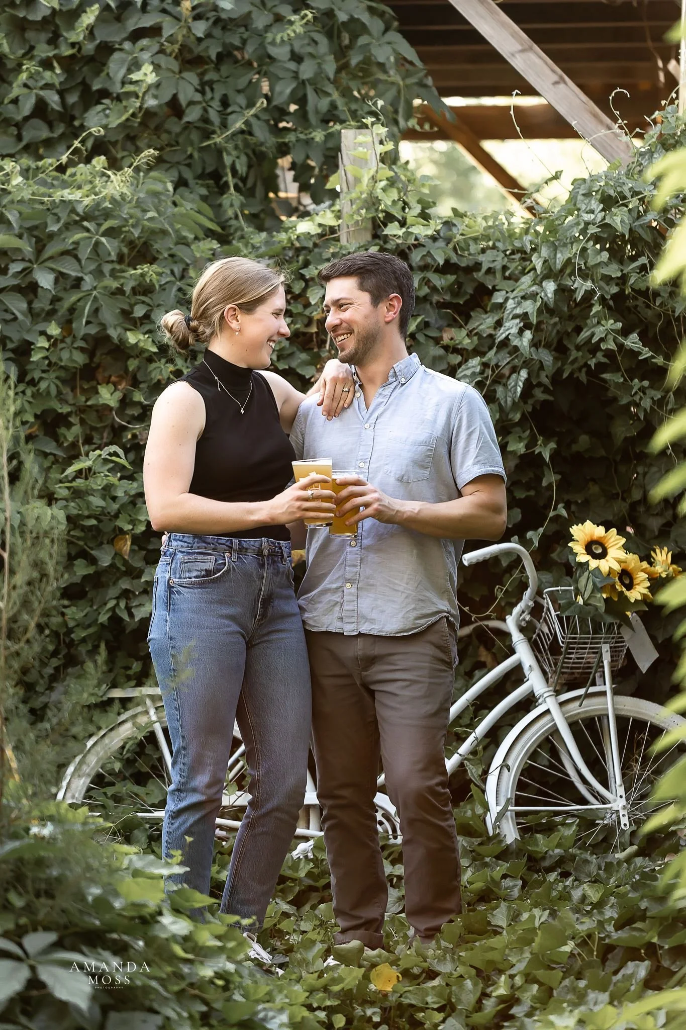 couple shares a beer during their engagement session in noda charlotte nc
