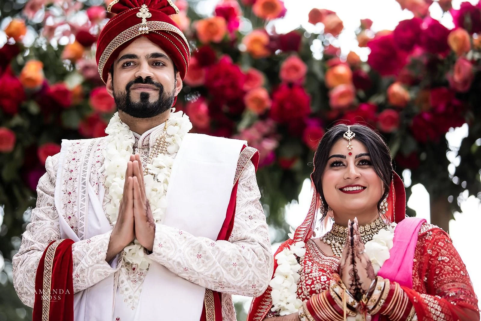 Indian bride and groom hold hands in prayer during hindu wedding ceremony