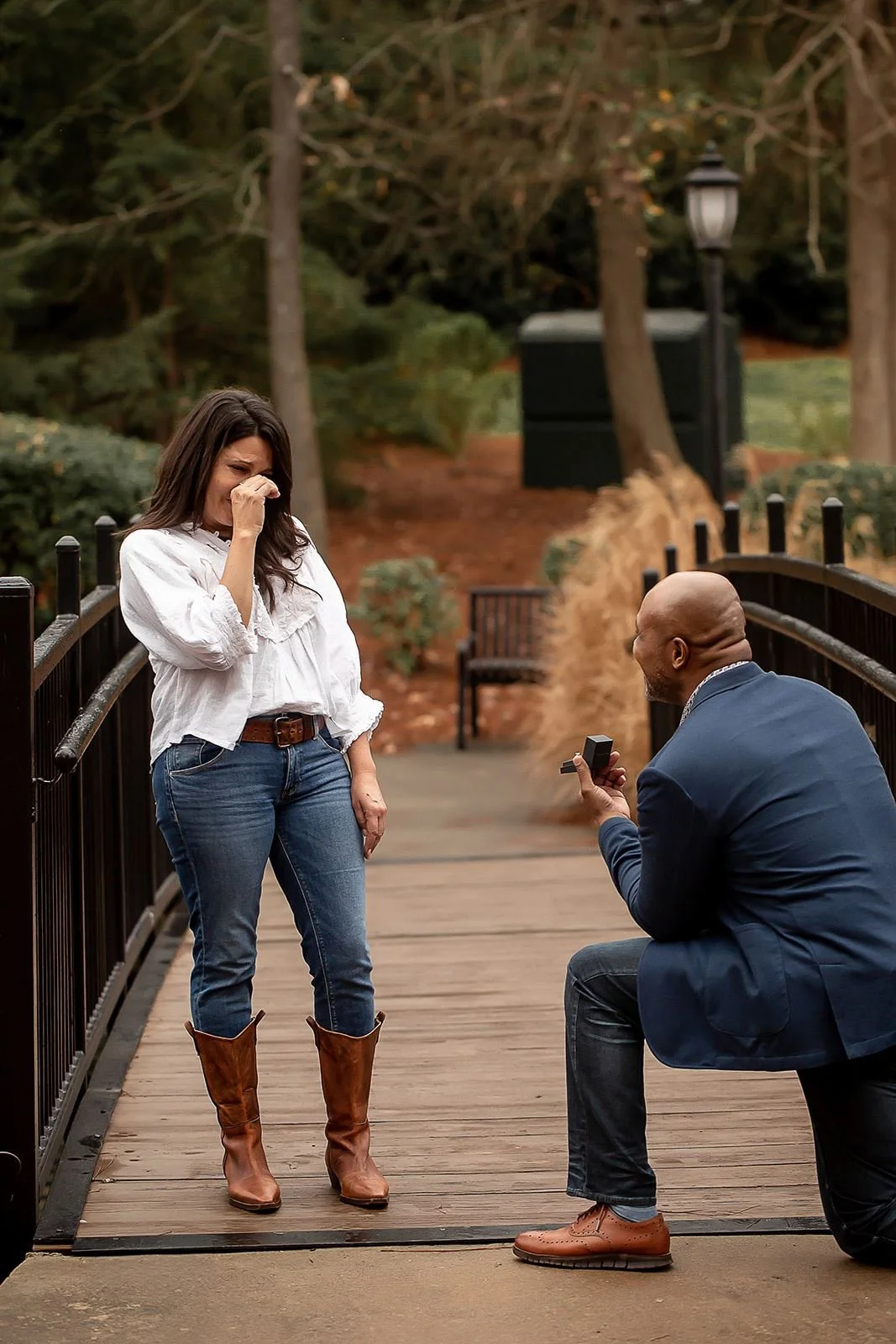 woman surprised to tears when boyfriend drops to one knee to propose