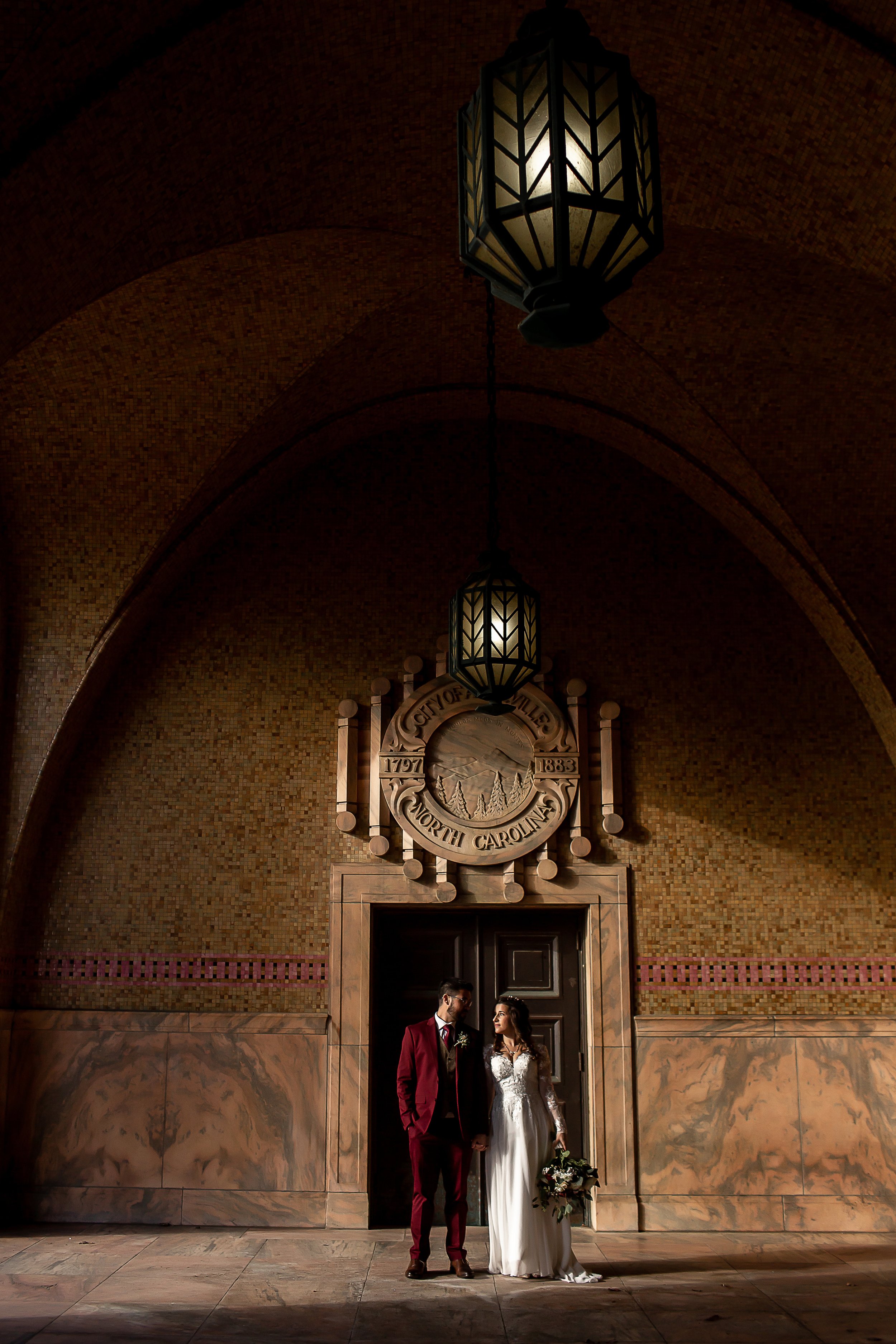 Bride and groom hold hands in strong shadow and architecture at the asheville nc courthouse