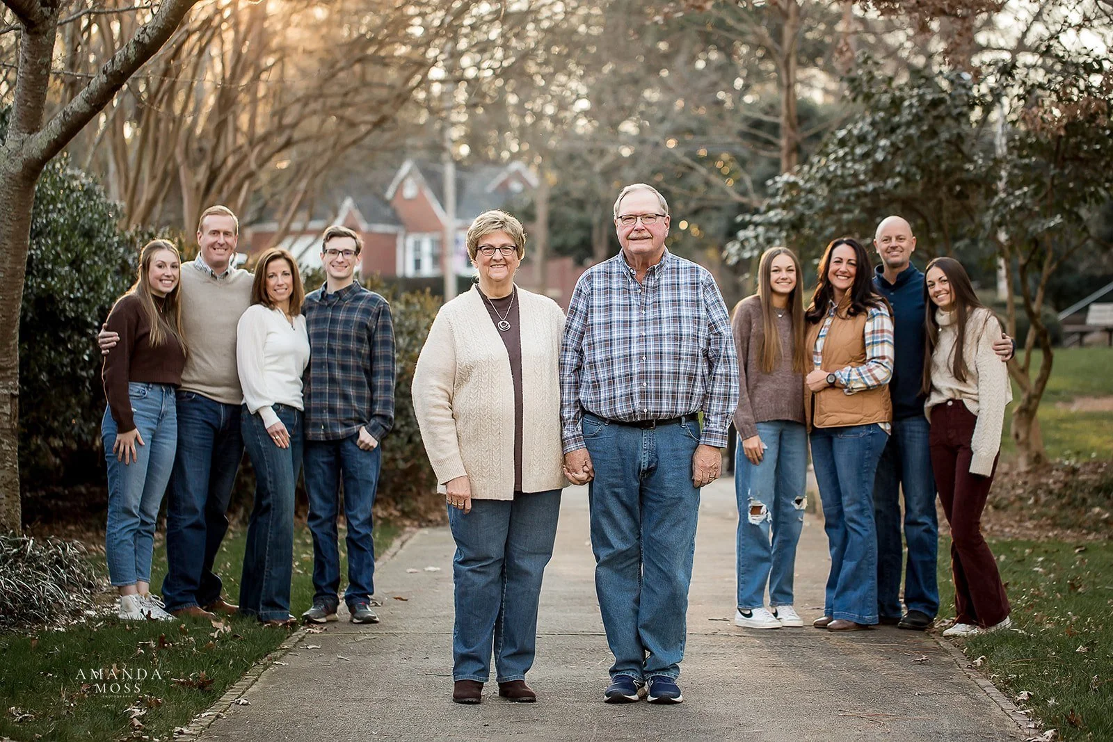 grandparents stand front and center with their children and grandchildren behind them in an extended family portrait