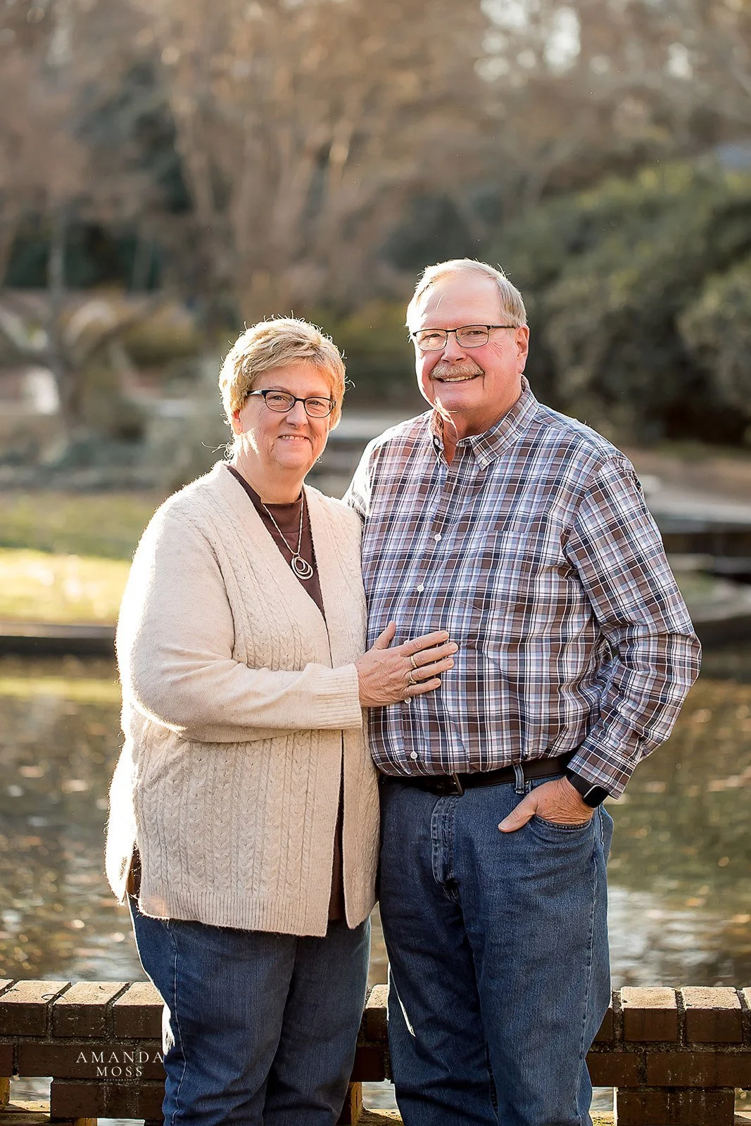 portrait of grandparents during the fall grandpa wears a plaid shirt and grandma wears a cream sweater
