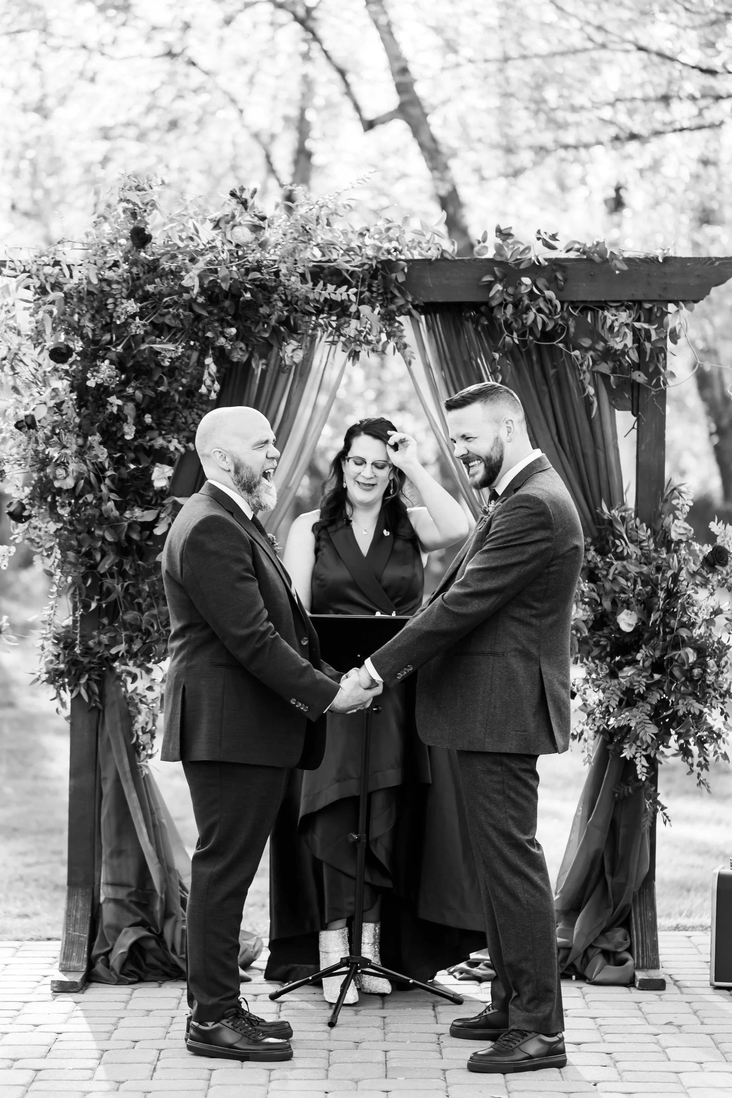 lgbt couple laughs during ceremony black and white photo
