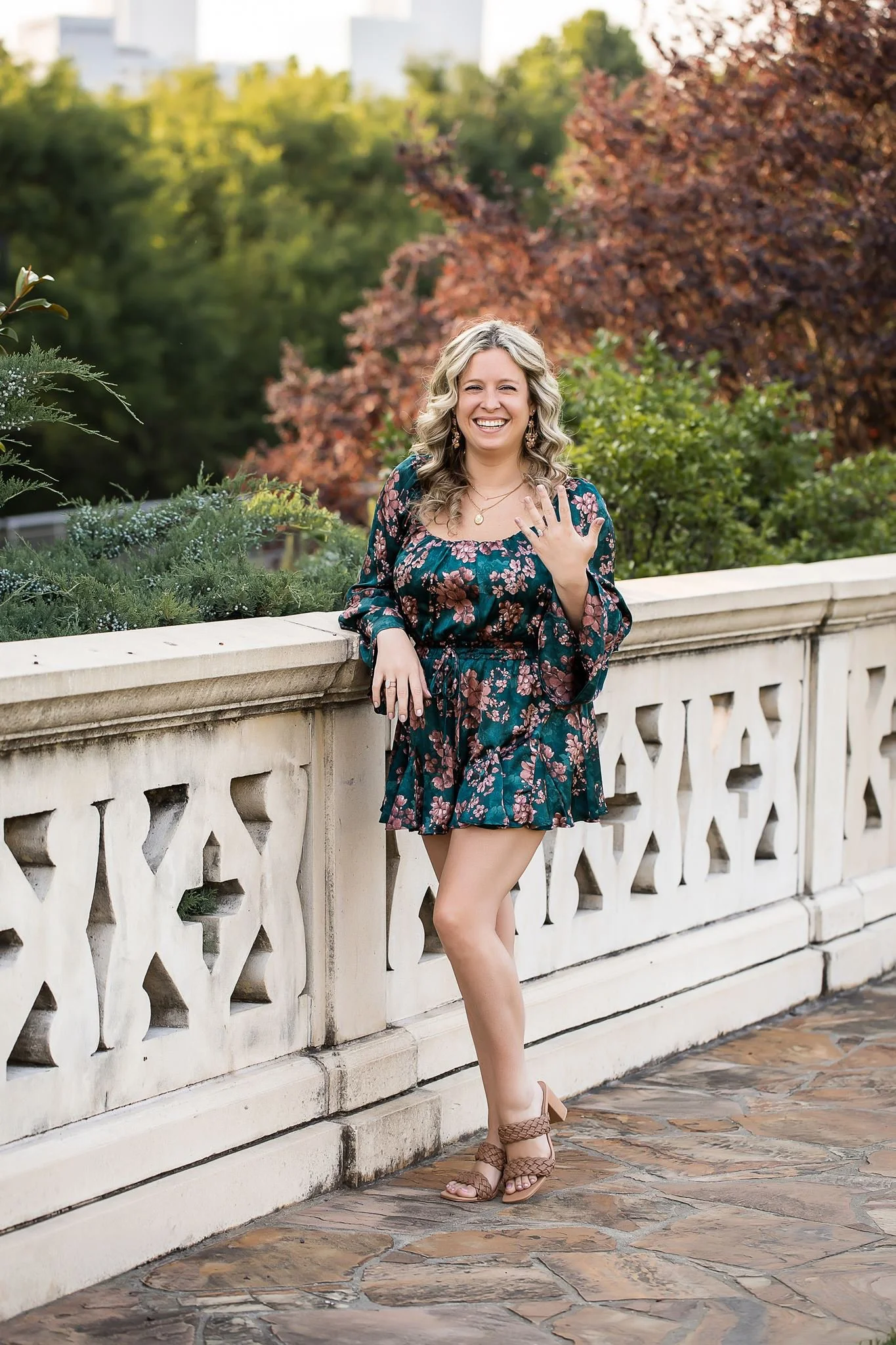 smiling woman in colorful jumper shows off new engagement ring