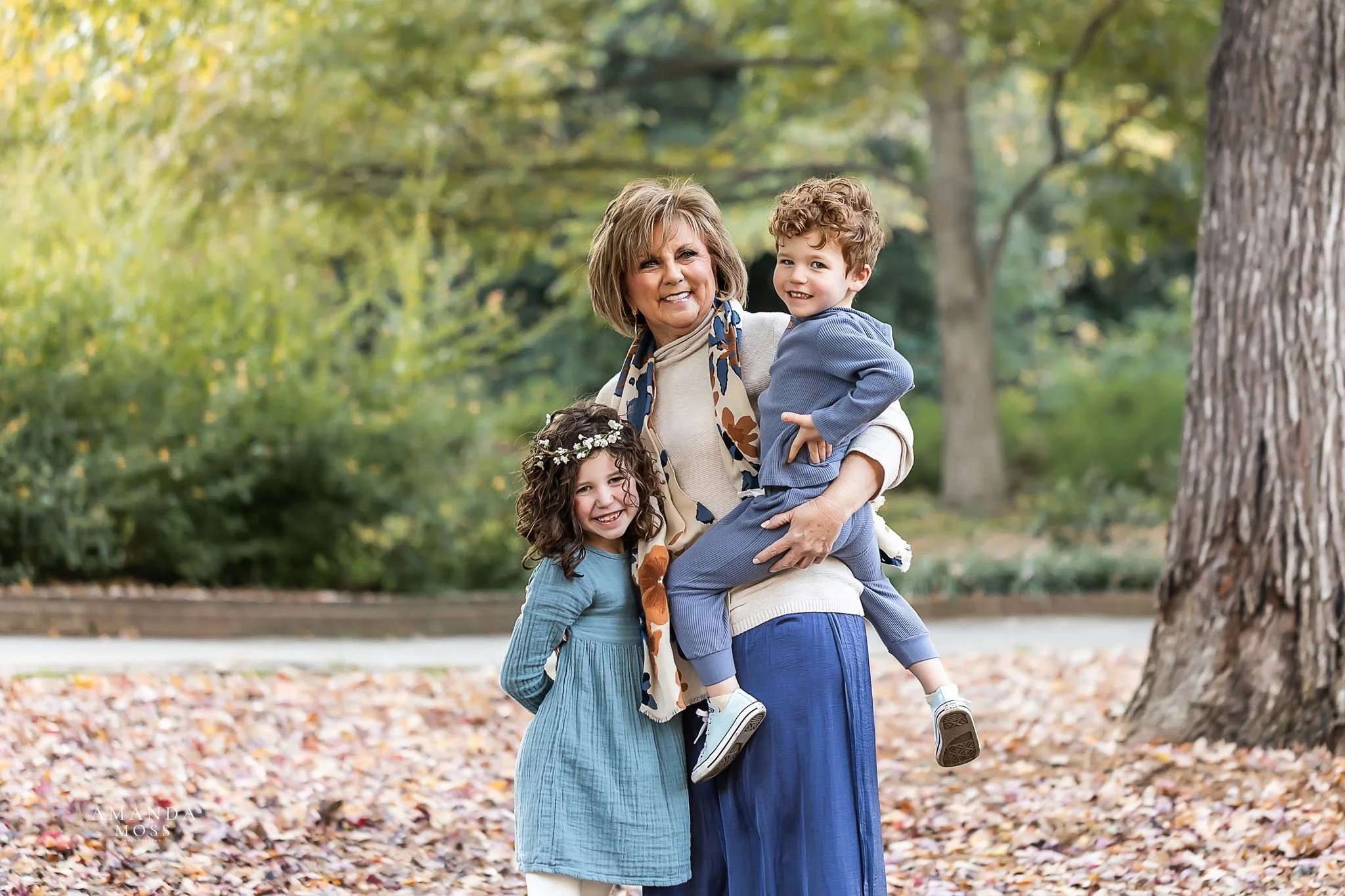 grandmother holds and hugs her grandchildren during outdoor family photo session at glencairn gardens in rock hill sc