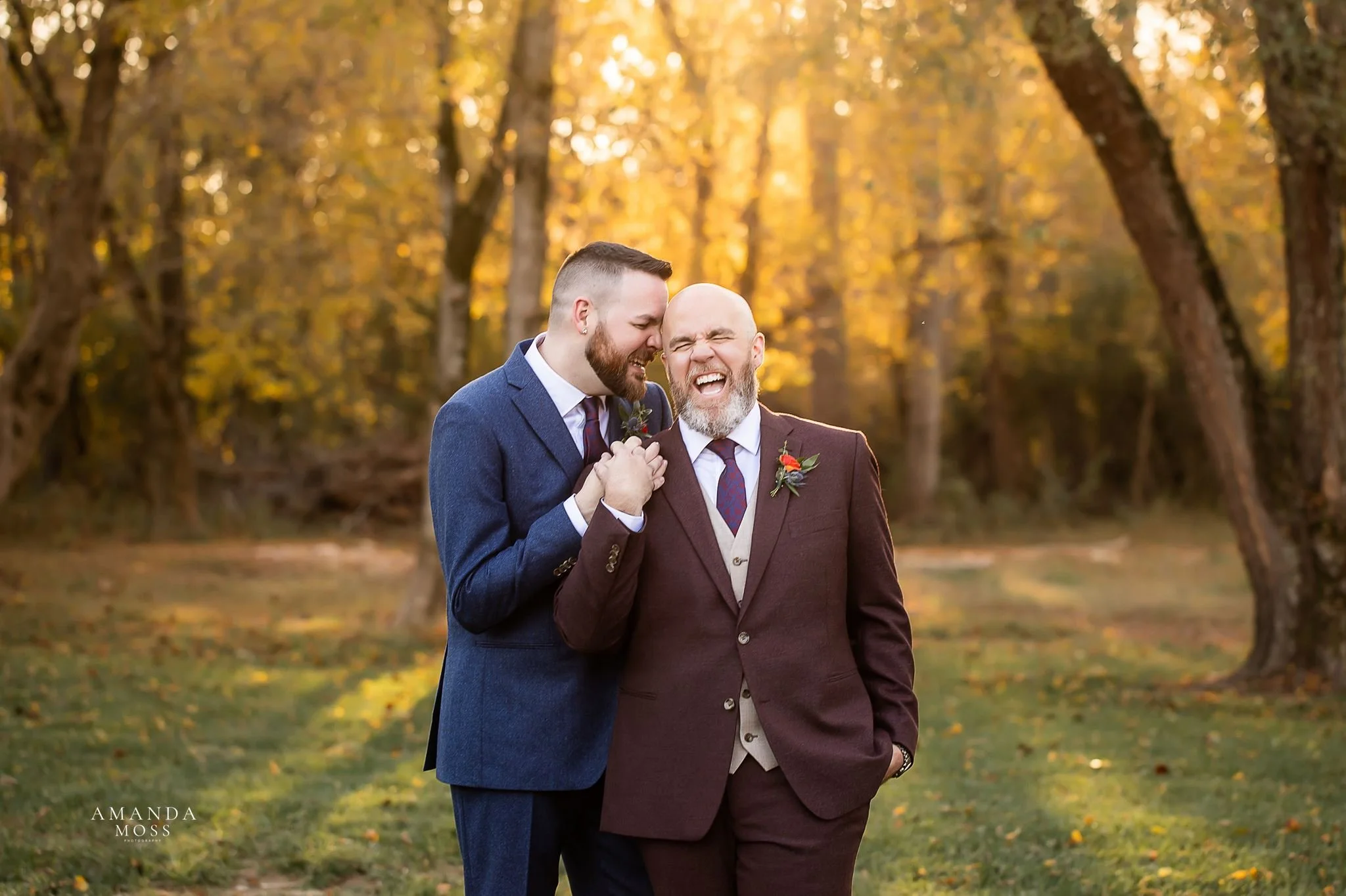 photo of two grooms embracing and laughing in the setting sun at outdoor wedding at providence cotton mill in maiden nc
