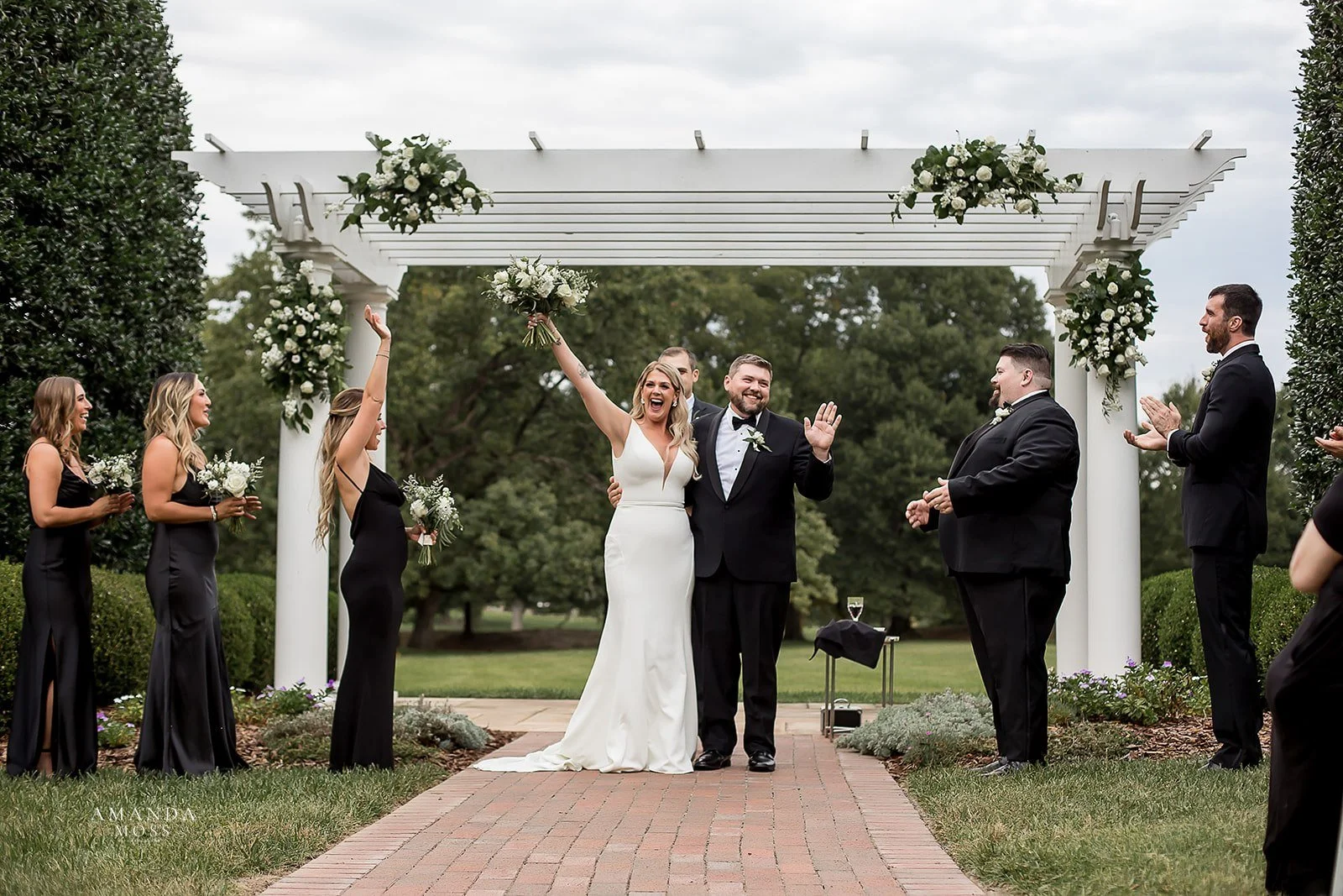 bride and groom cheer after their black tie outdoor wedding ceremony in north carolina