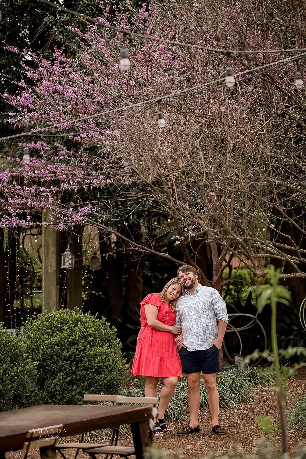 woman rests head on her fiances shoulder during outdoor engagement session at rosies wine bar in charlotte nc