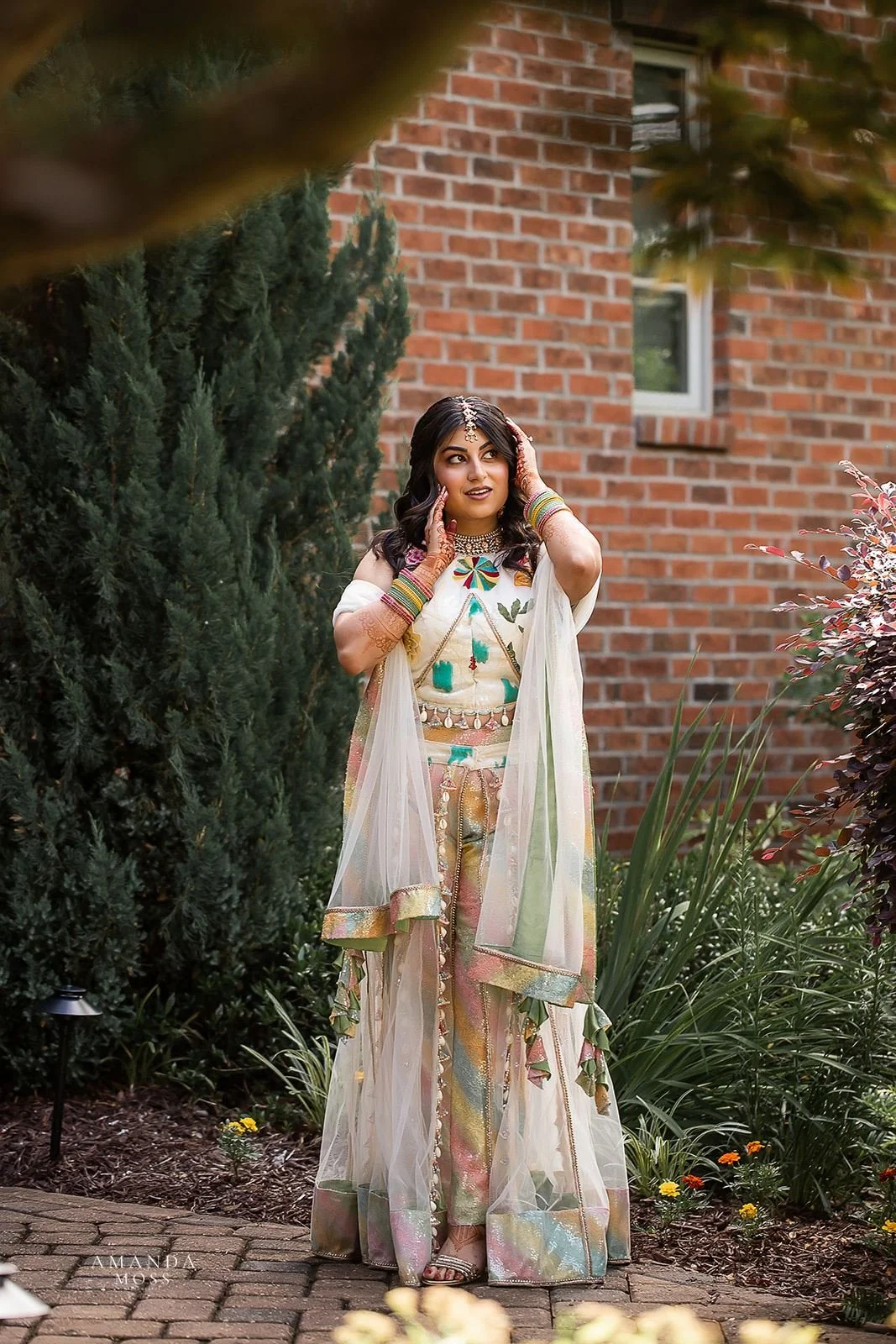 hindu bride poses for camera at her mendhi ceremony