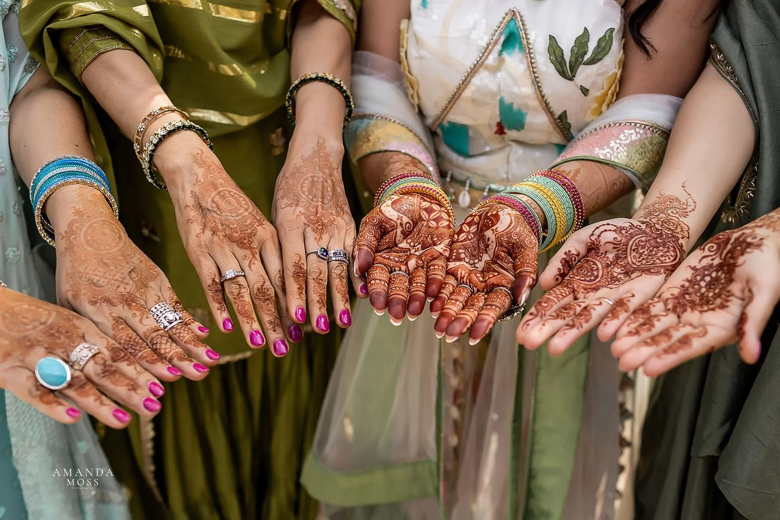 Hindu bride and friends show off henna on hands before wedding