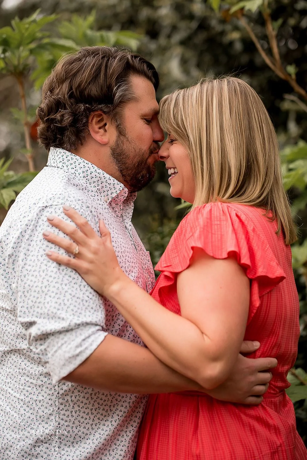man kisses fiance on nose during outdoor engagement session at rosies wine bar in charlotte nc