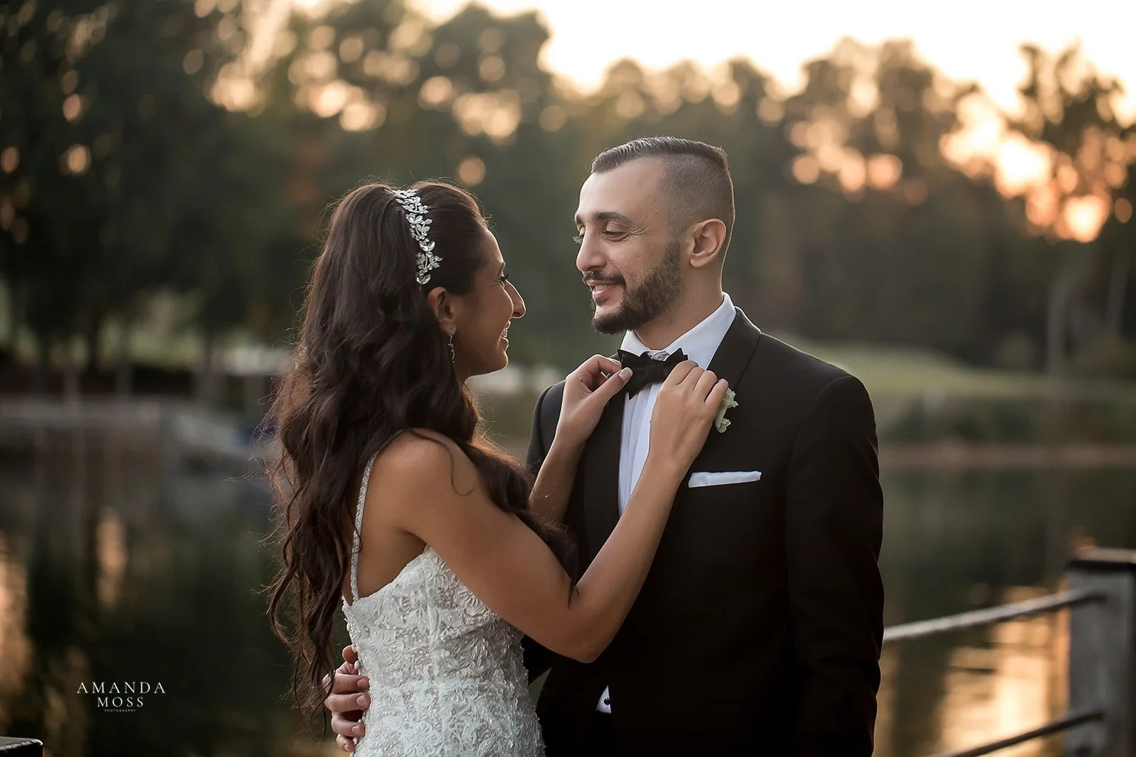 bride adjust grooms bowtie outside of trump national golf club at lake norman wedding